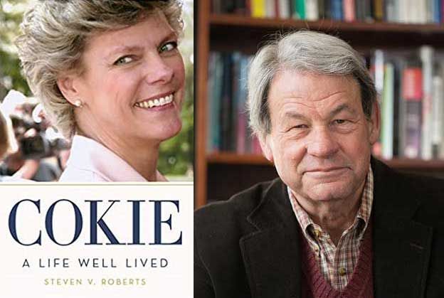 A man and a woman are standing next to each other in front of a bookshelf.