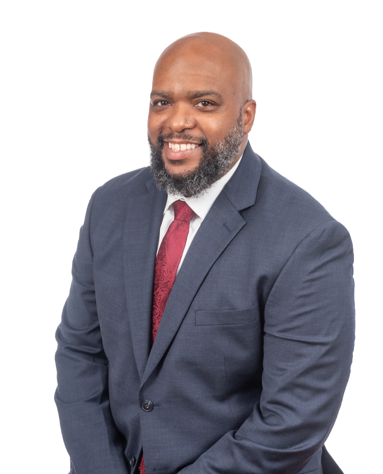 Man in a blue suit with a red tie smiling, against a white background.