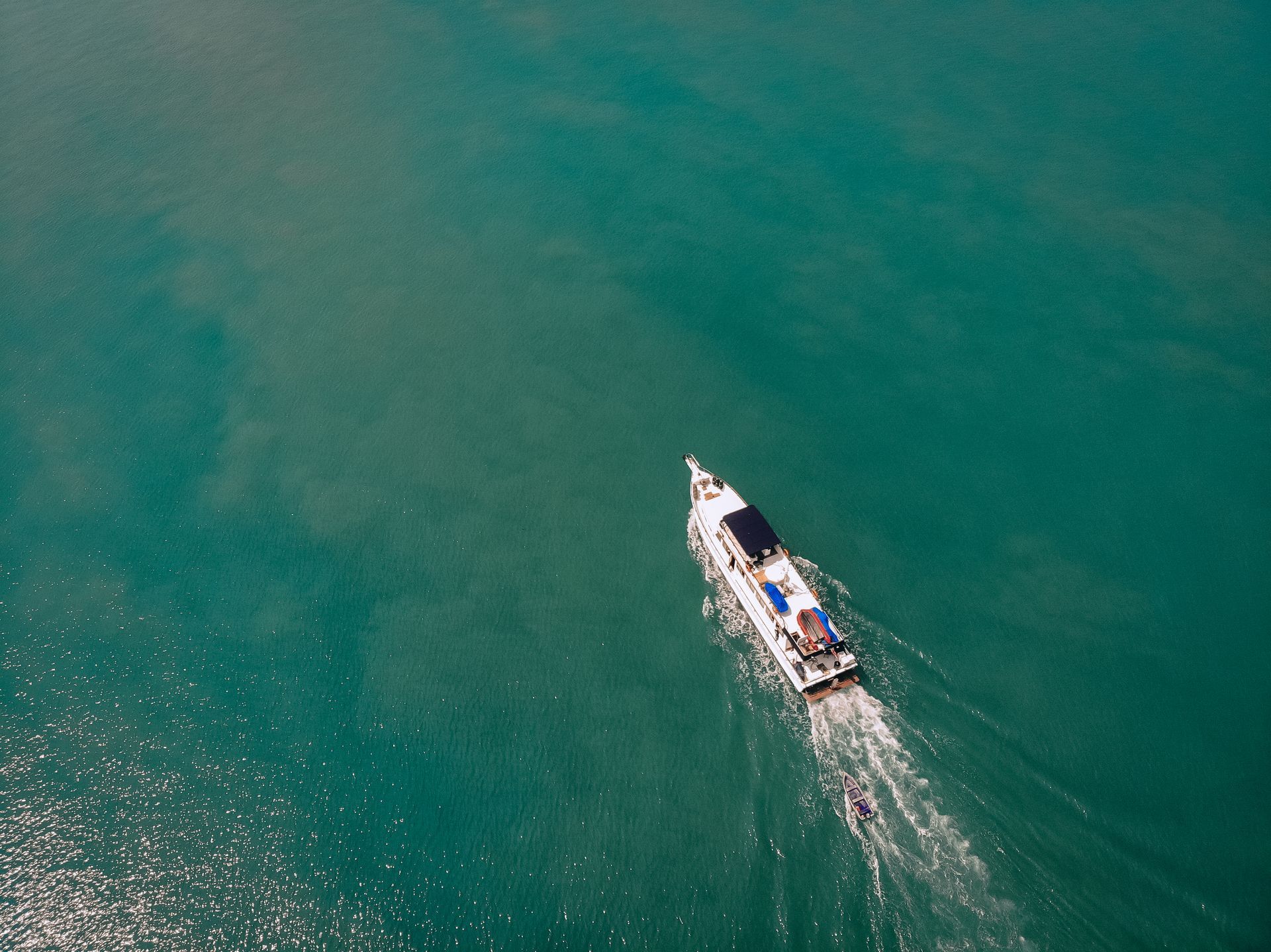 Boat travels across turquoise water, leaving a white wake.