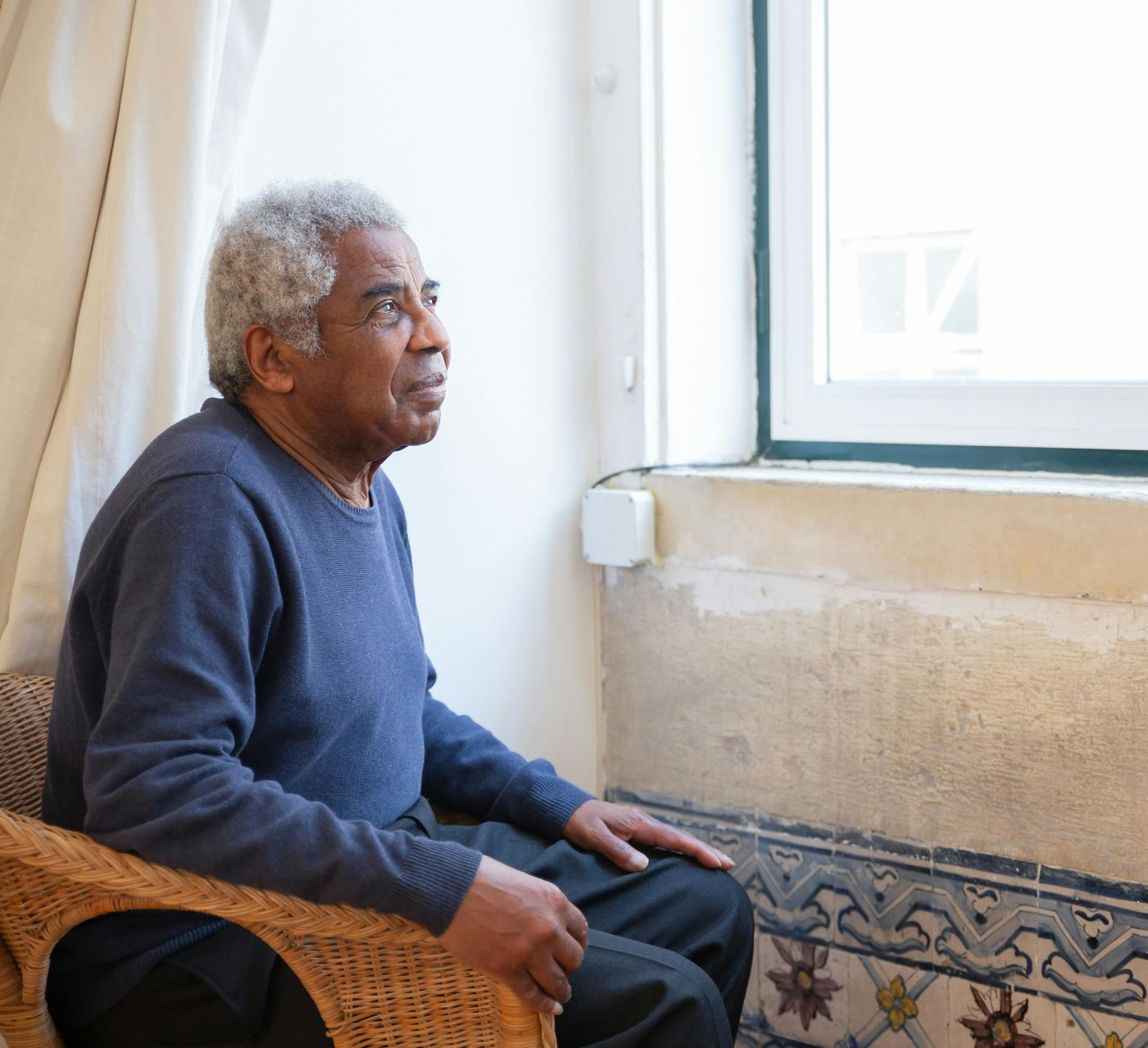 Woman hugs an older person; both smile broadly, outdoor setting. 