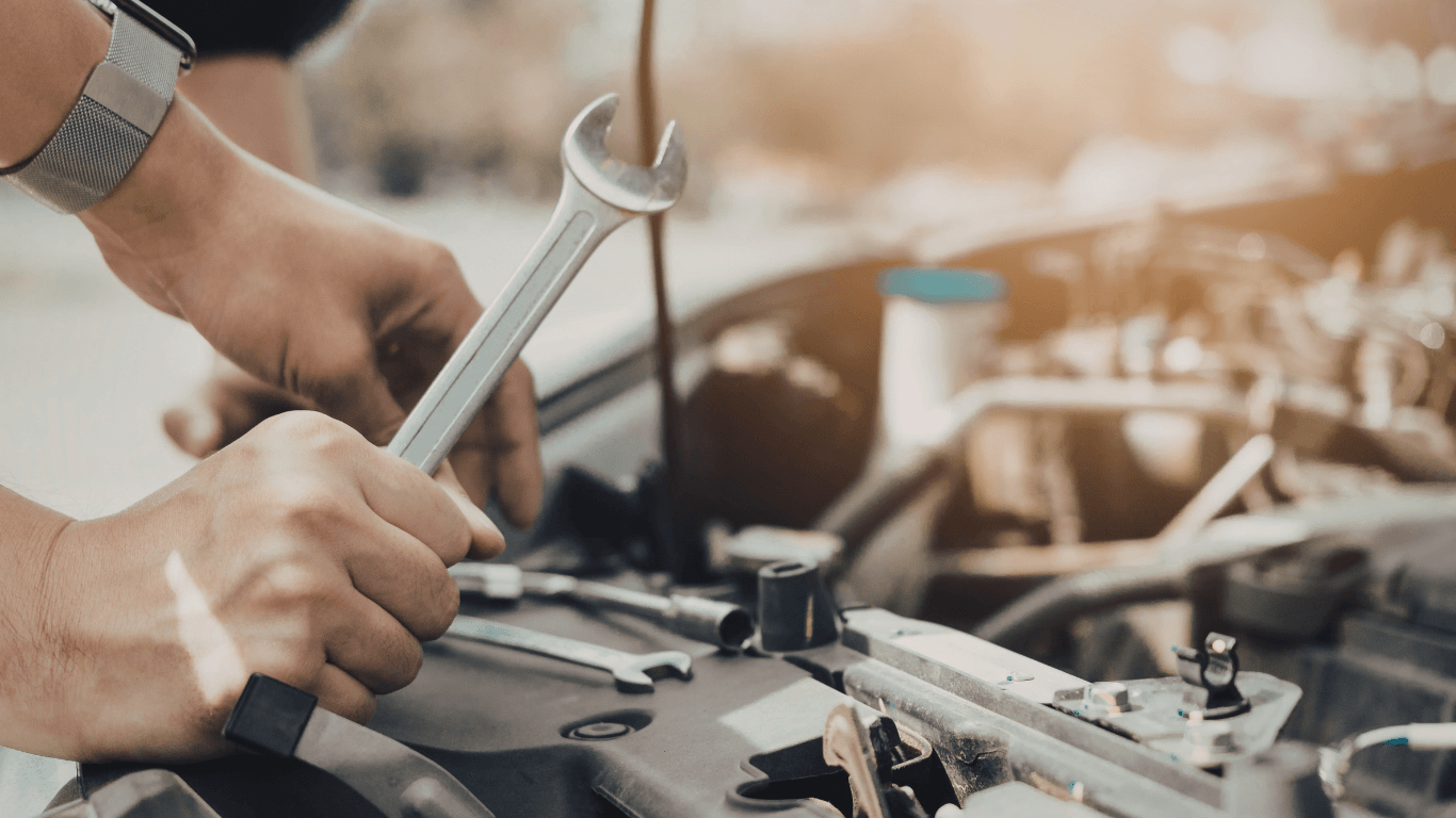 a mobile mechanic doing an auto repair with a wrench