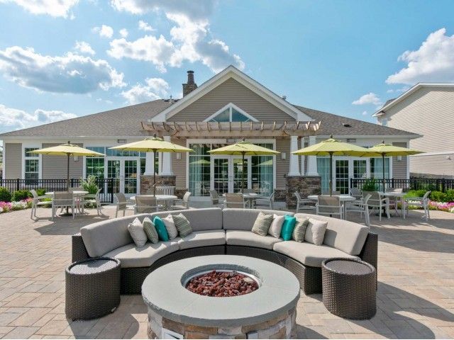 Gradient apartment community outdoor firepit amenity with outdoor sofa.