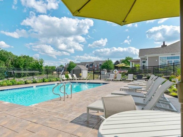 Gradient apartment community luxury outdoor pool with poolside lounge.