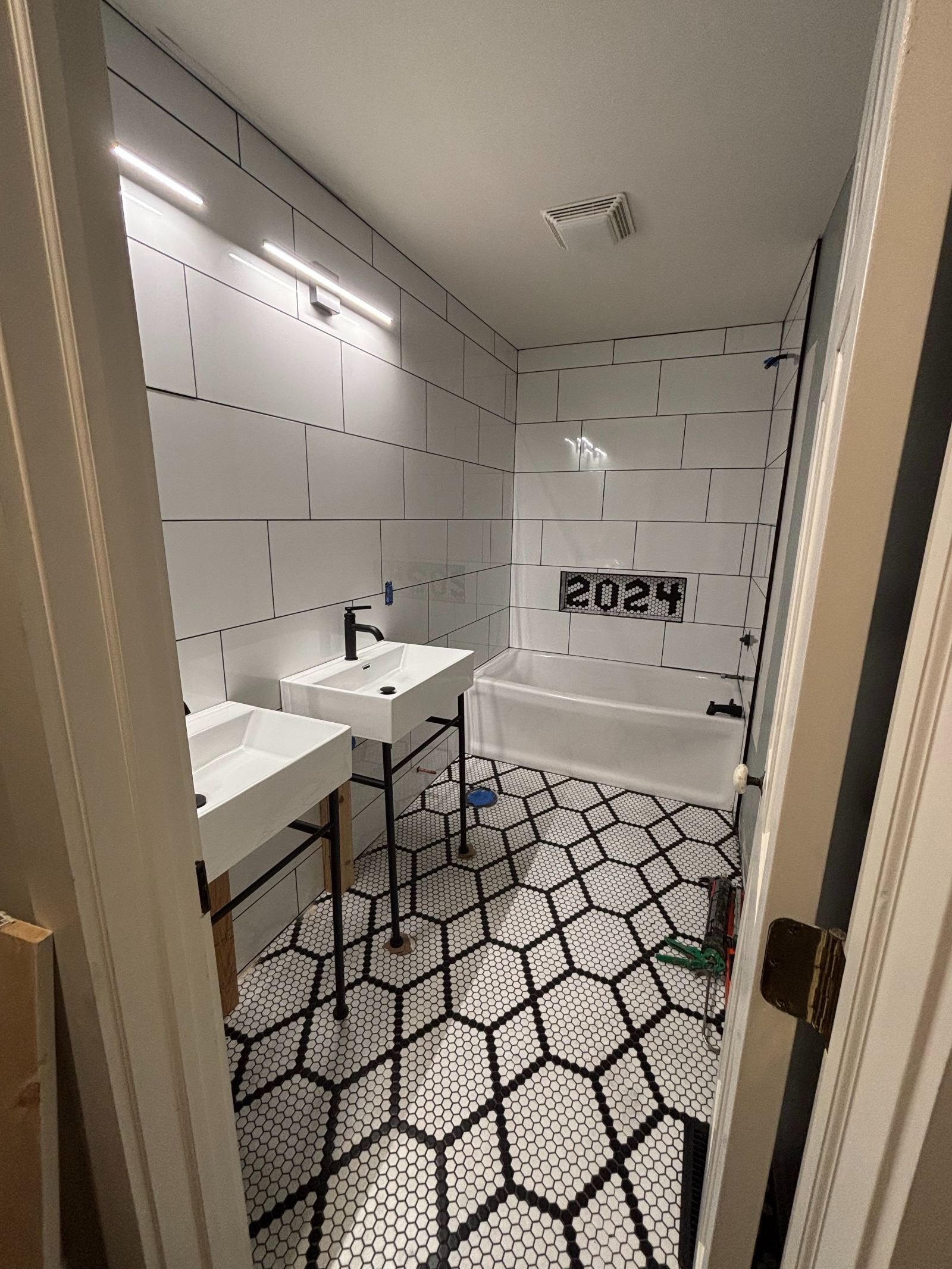 A bathroom with two sinks and a bathtub under construction.