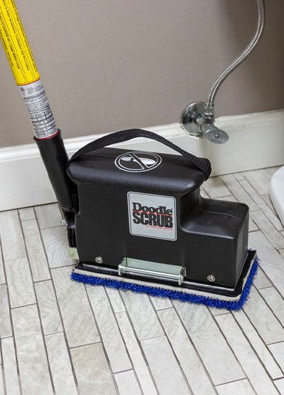 A doodle scrub is being used to clean a tile floor.