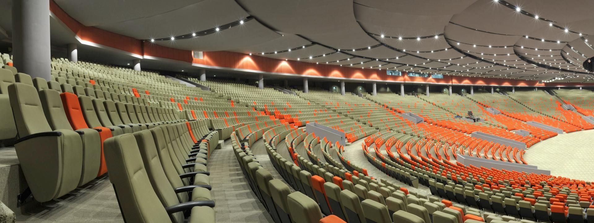 A full scope view of Ferco Seating at a Convention Center. The Seats are grey with orange sprinkled in for a stunning look.