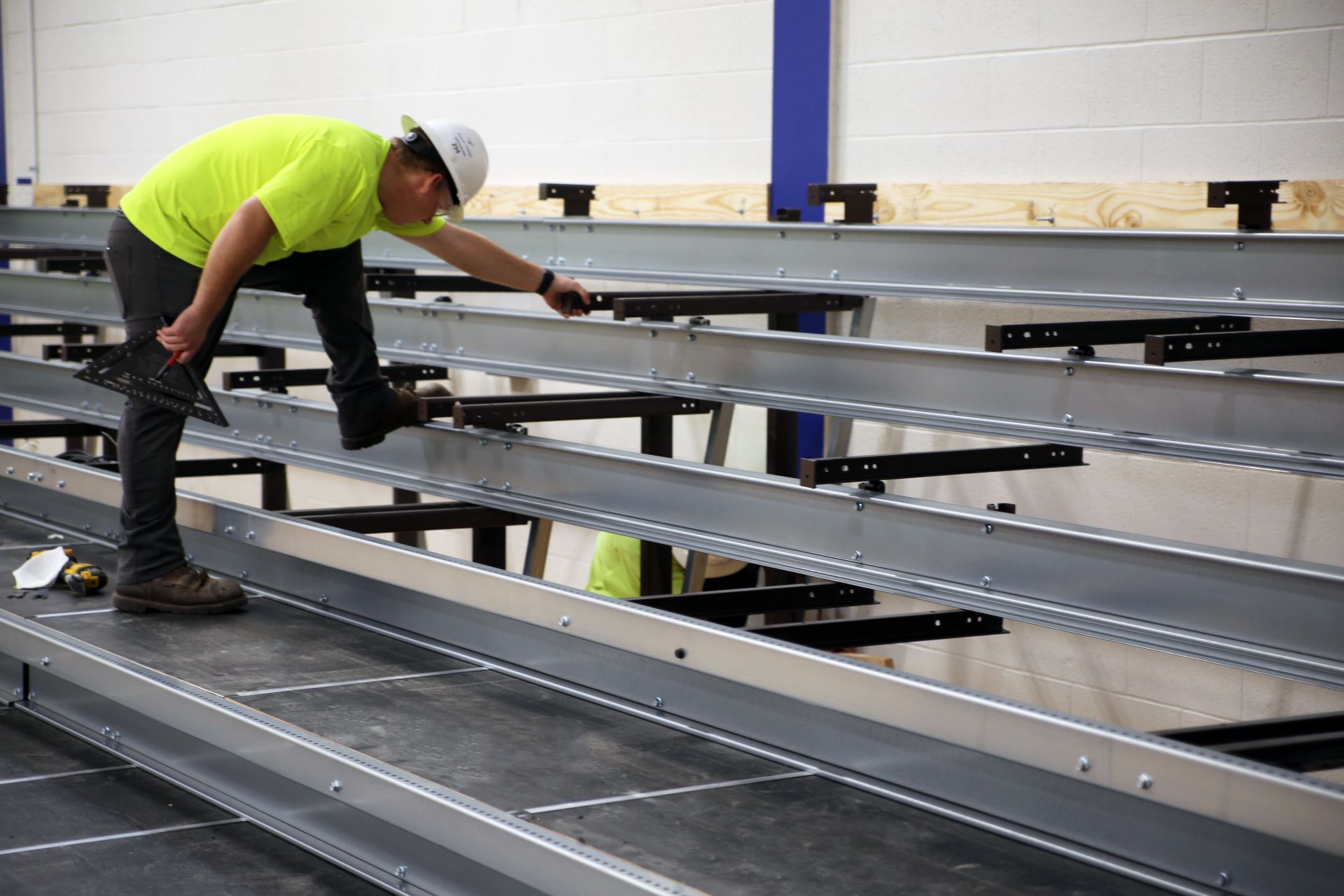 Kalamazoo Seating Service Group employees installing a telescopic bleacher system at the local high school.