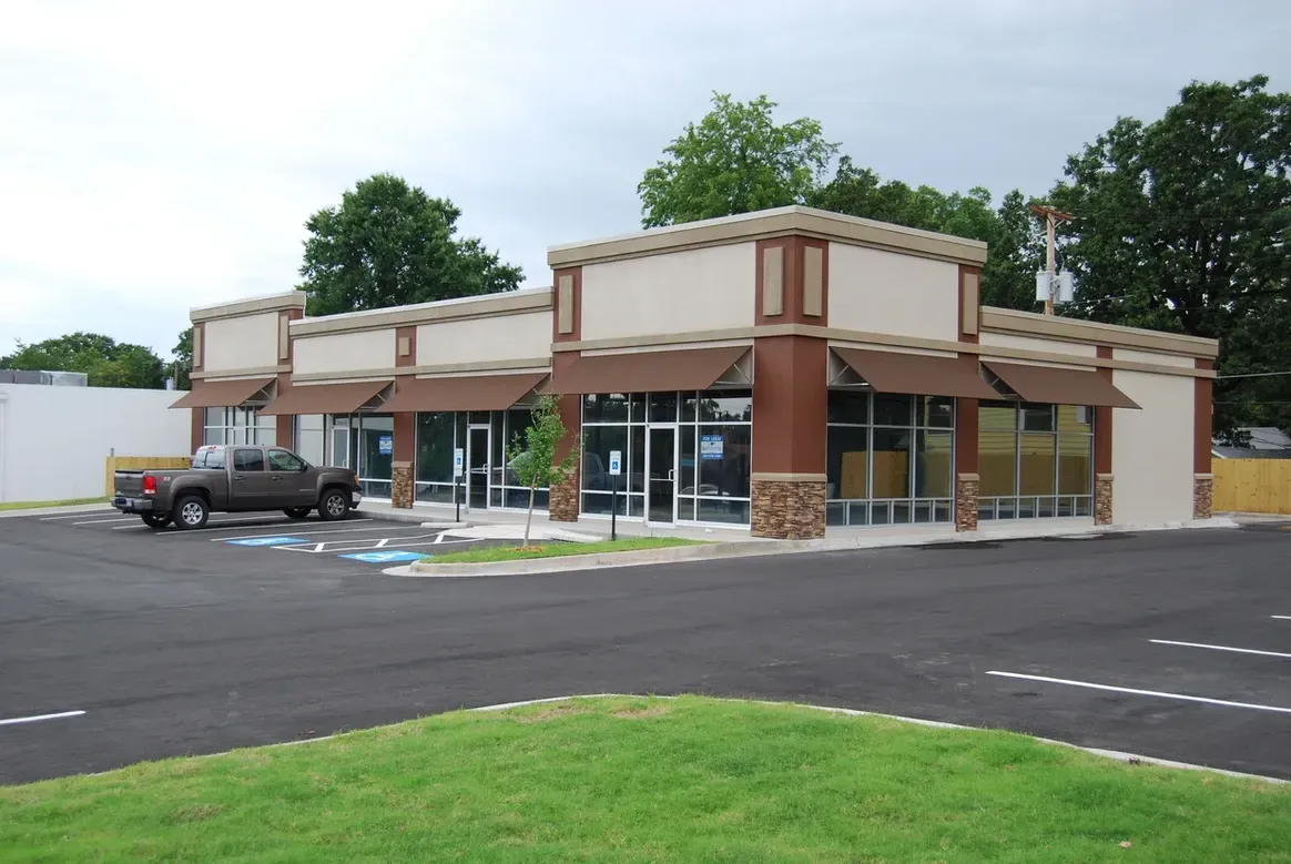 A truck is parked in front of a building with awnings