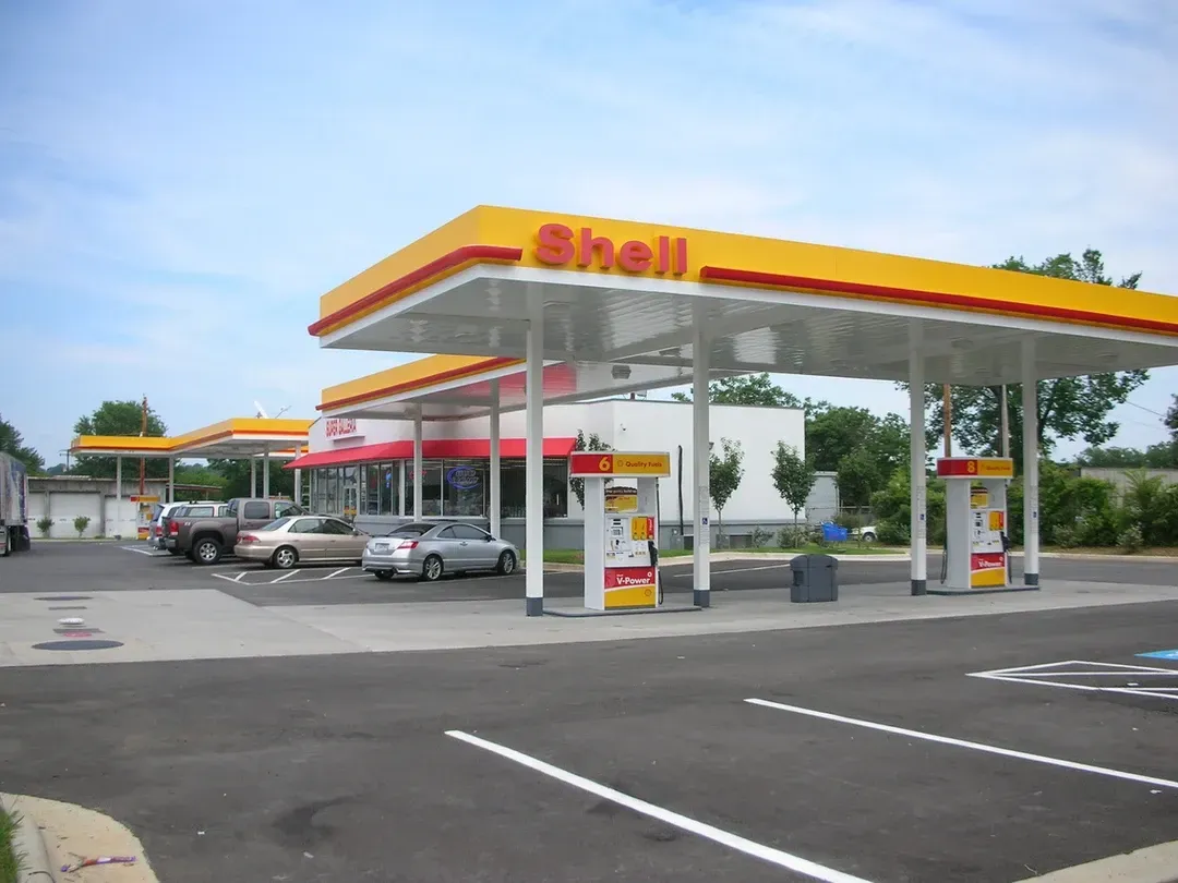 A shell gas station with cars parked in front of it