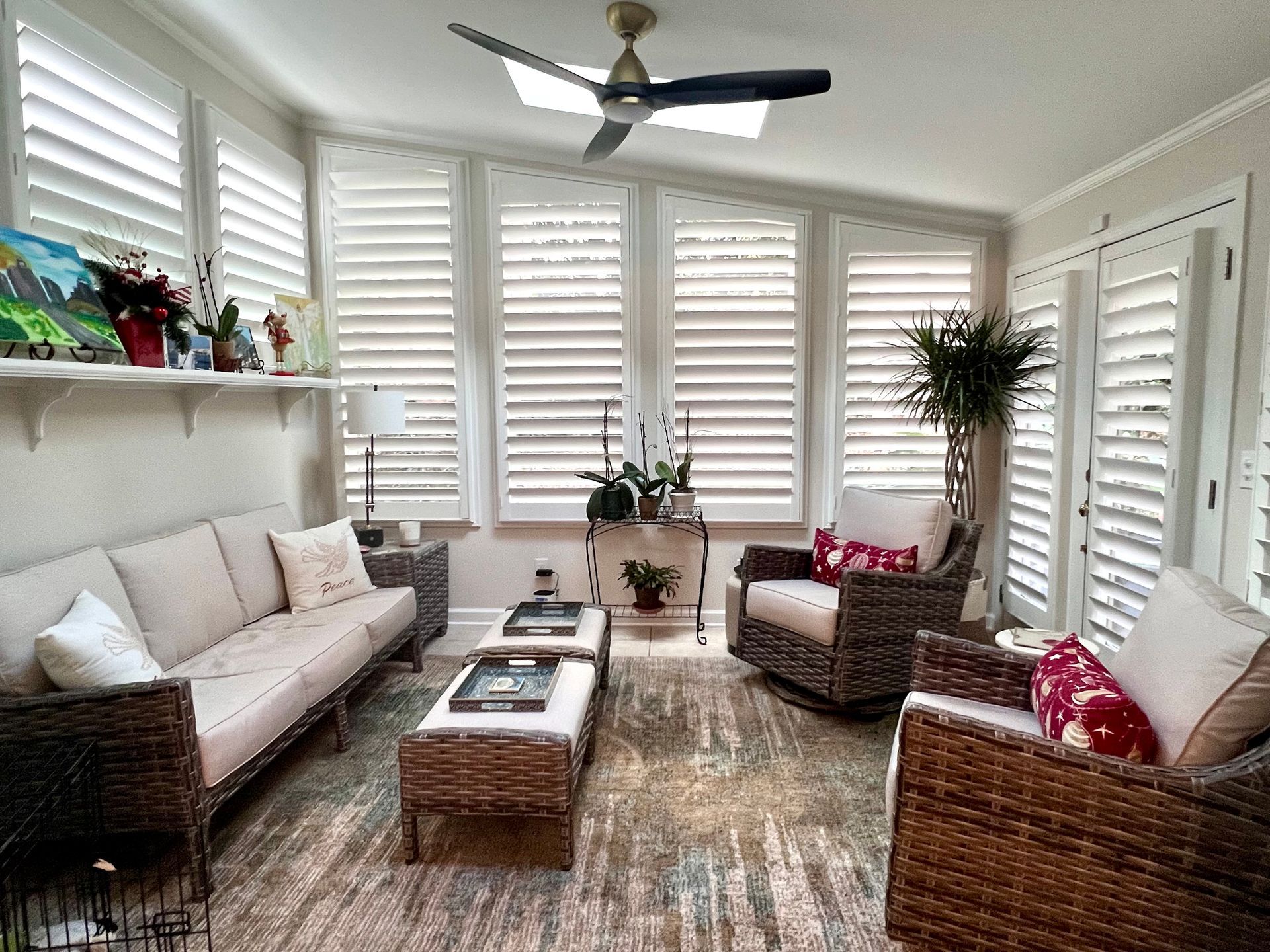 A living room with a couch , chairs , and a ceiling fan.