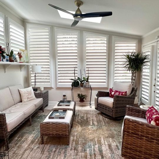 A living room with a couch , chairs , and a ceiling fan.