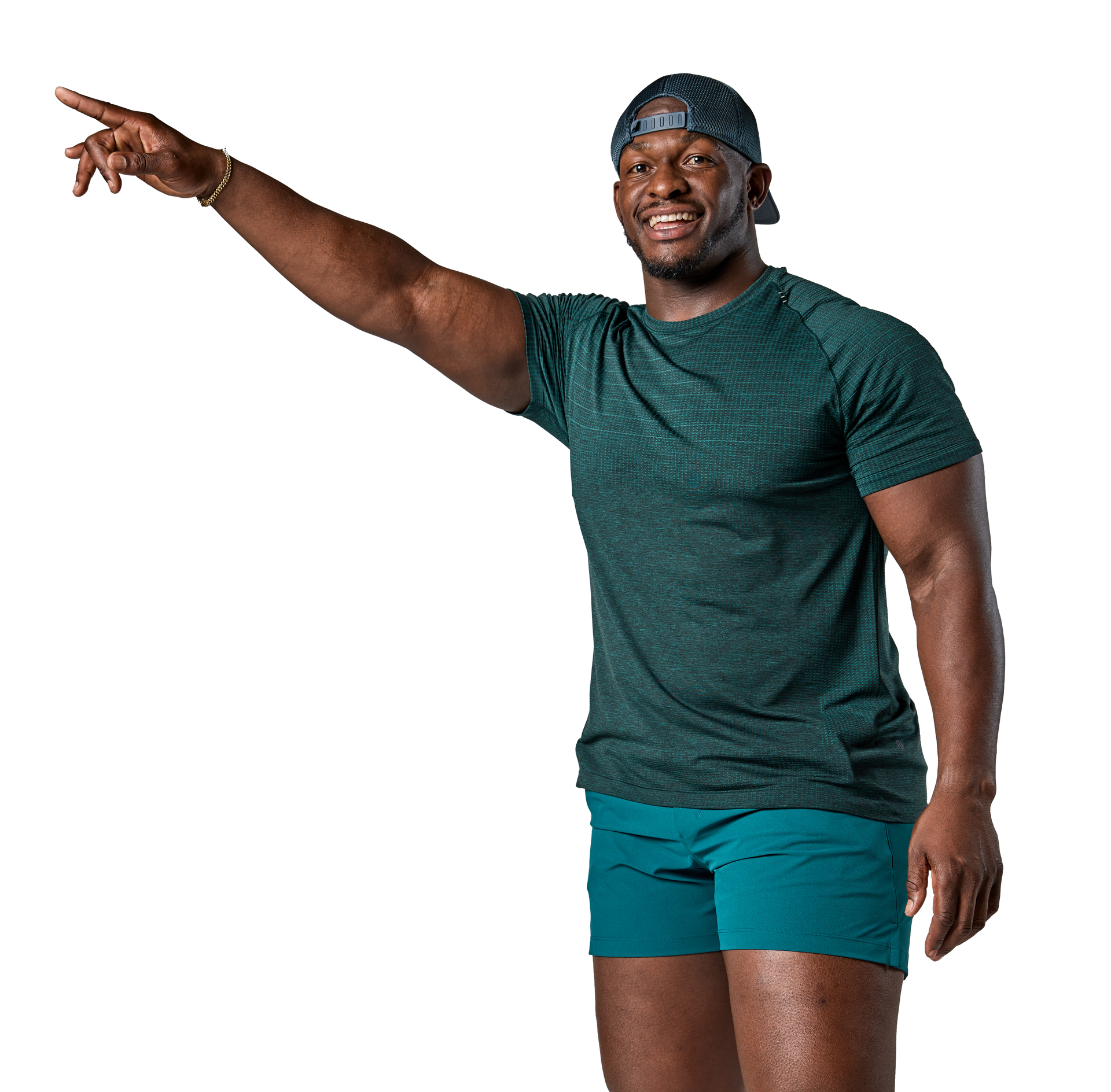 A man in a green shirt and blue shorts is pointing at something.