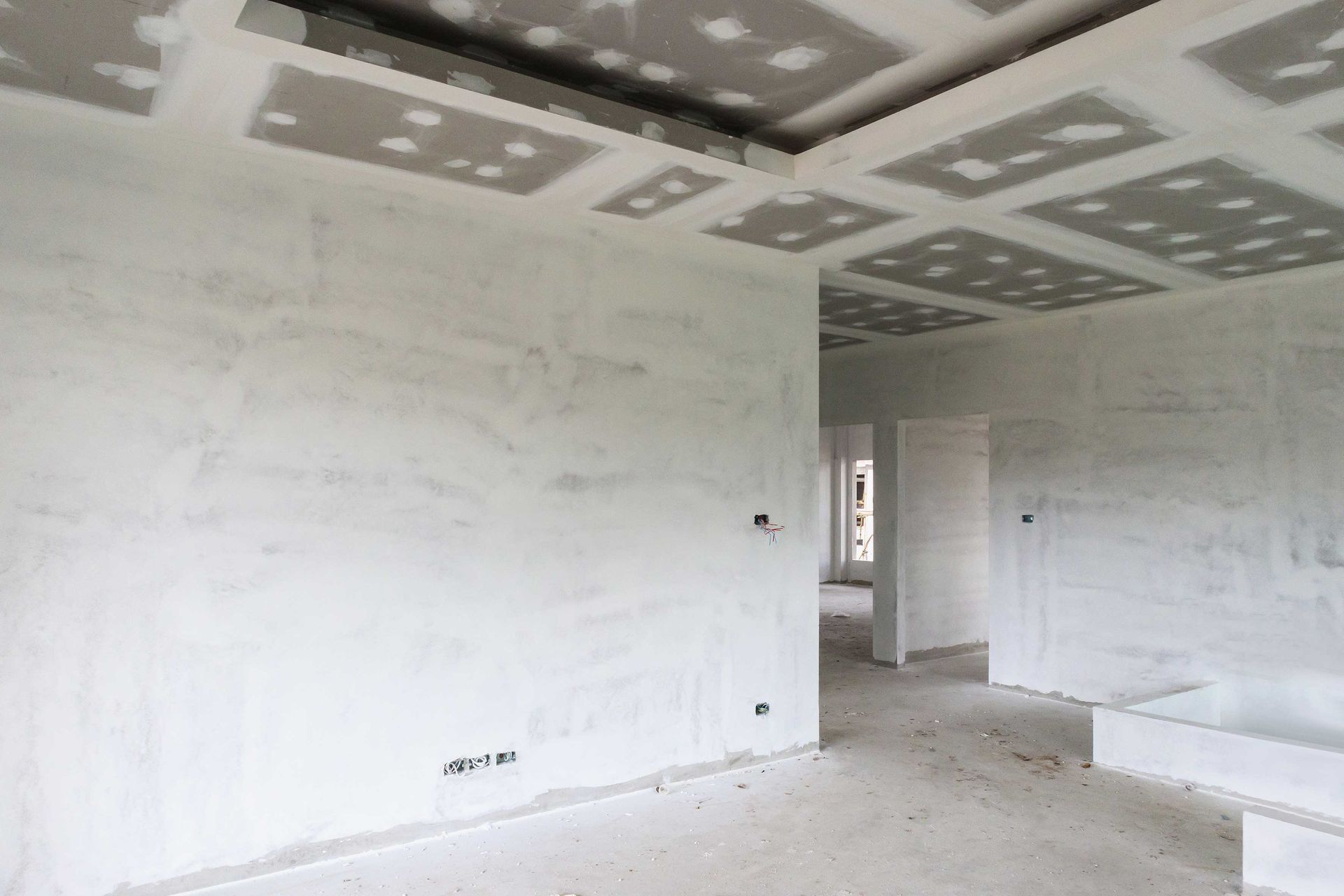 An empty room with white walls and a ceiling in a house under construction.
