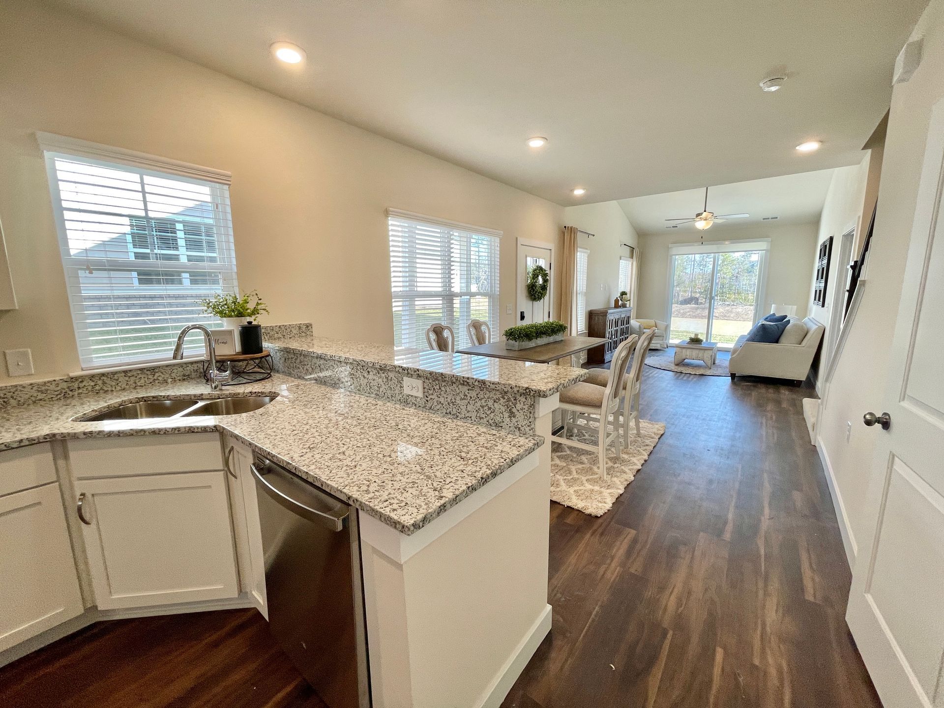 A kitchen with granite counter tops and a stainless steel dishwasher.