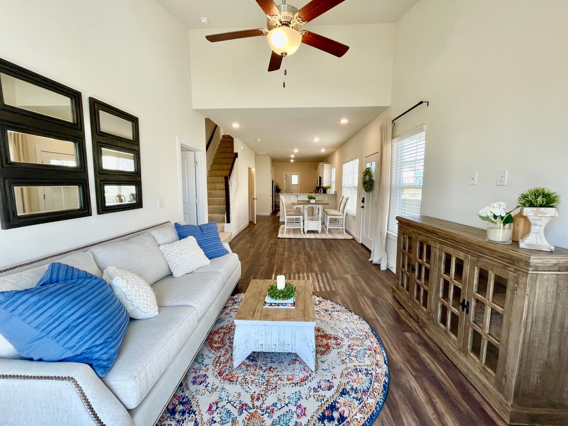 A living room with a couch , coffee table , and ceiling fan.