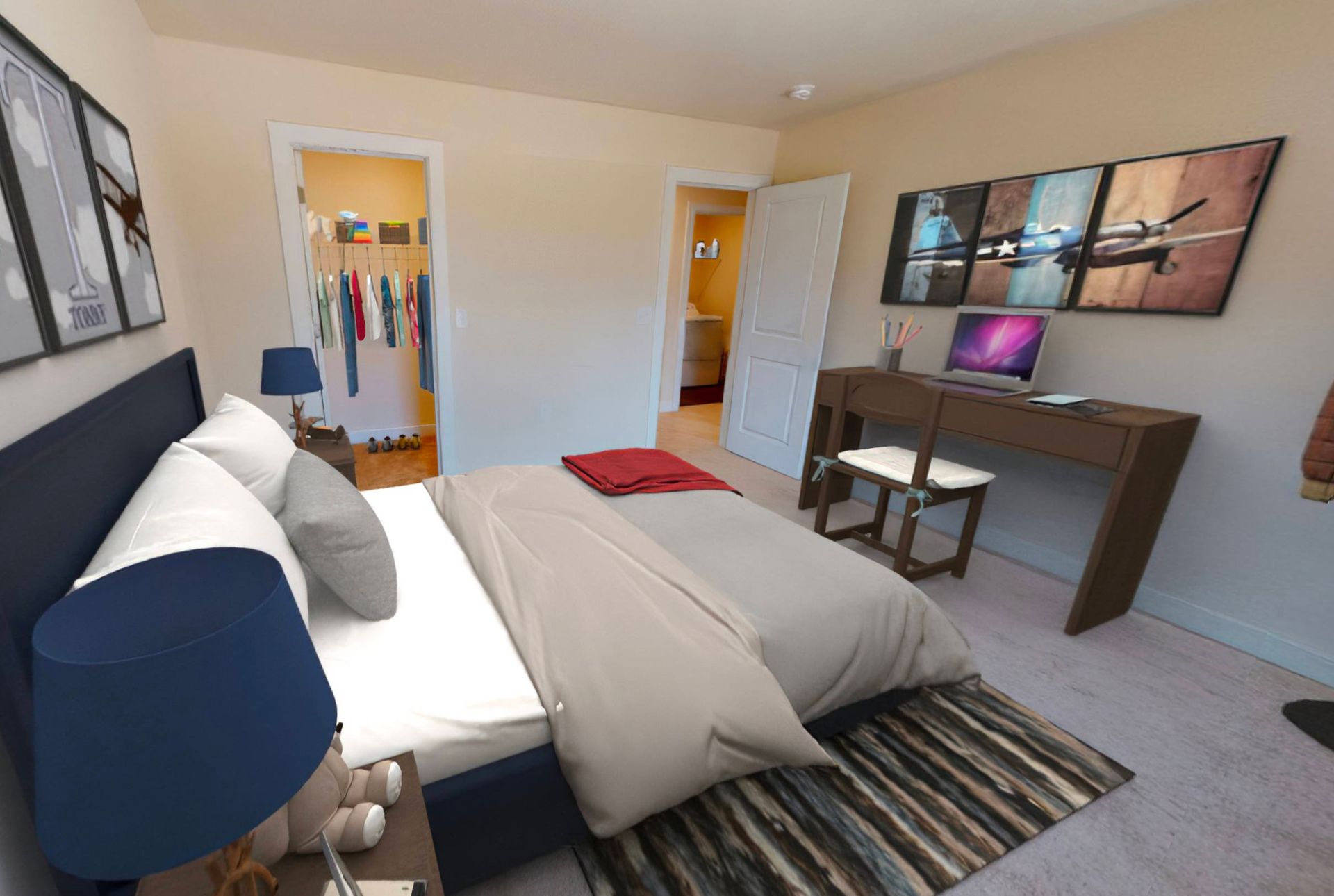 A bedroom with a large bed and a desk with a laptop on it