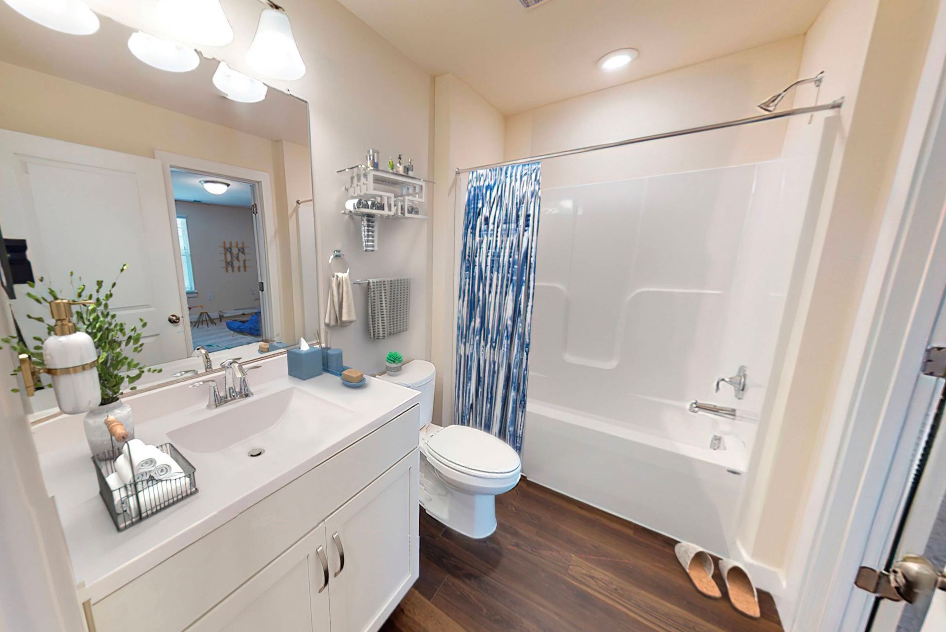 A bathroom with a sink , toilet , bathtub and mirror.