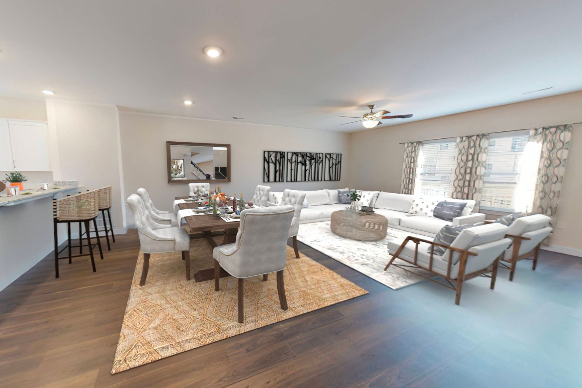 A living room with a couch , chairs , a table and a ceiling fan.