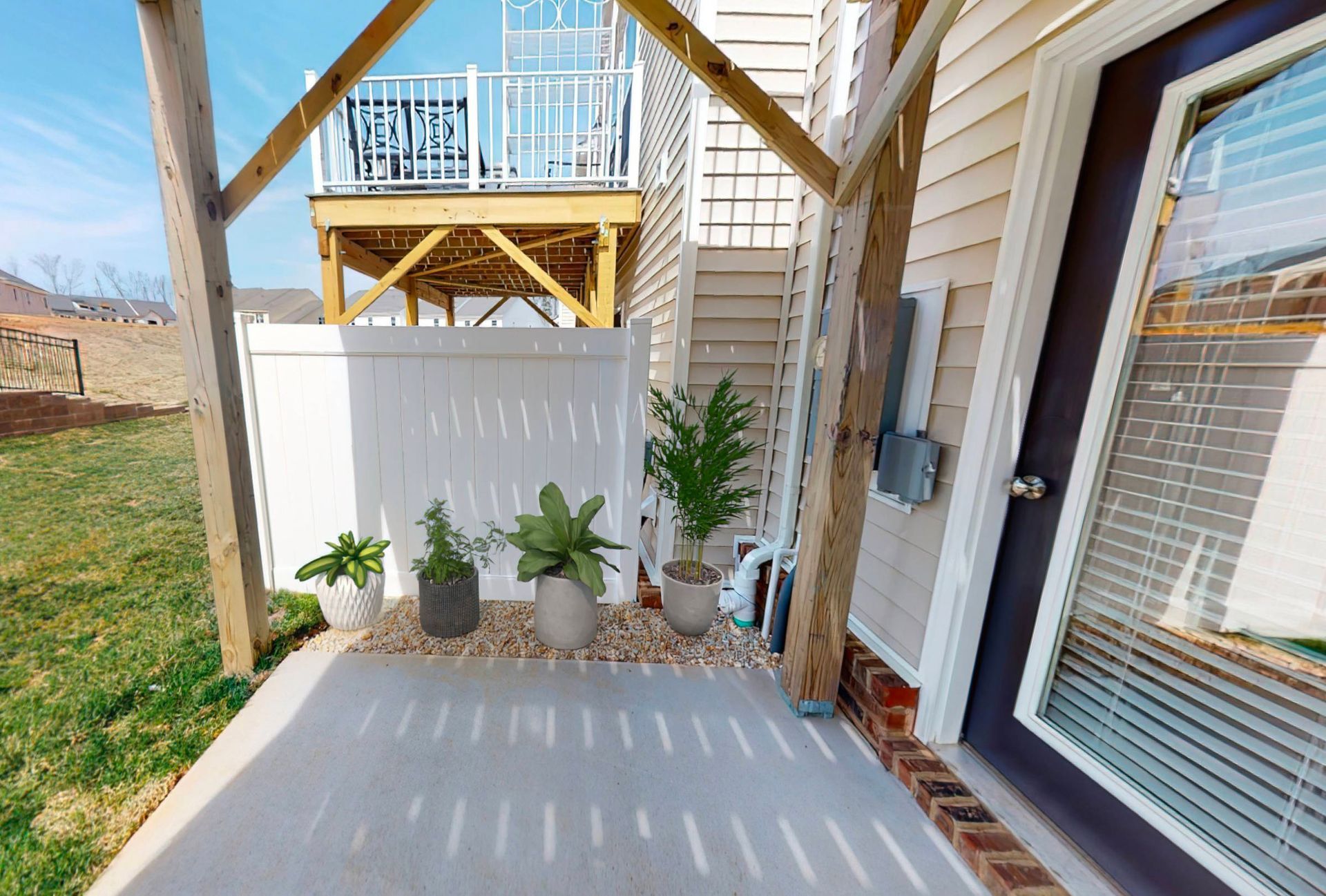 A patio with potted plants and a sliding glass door