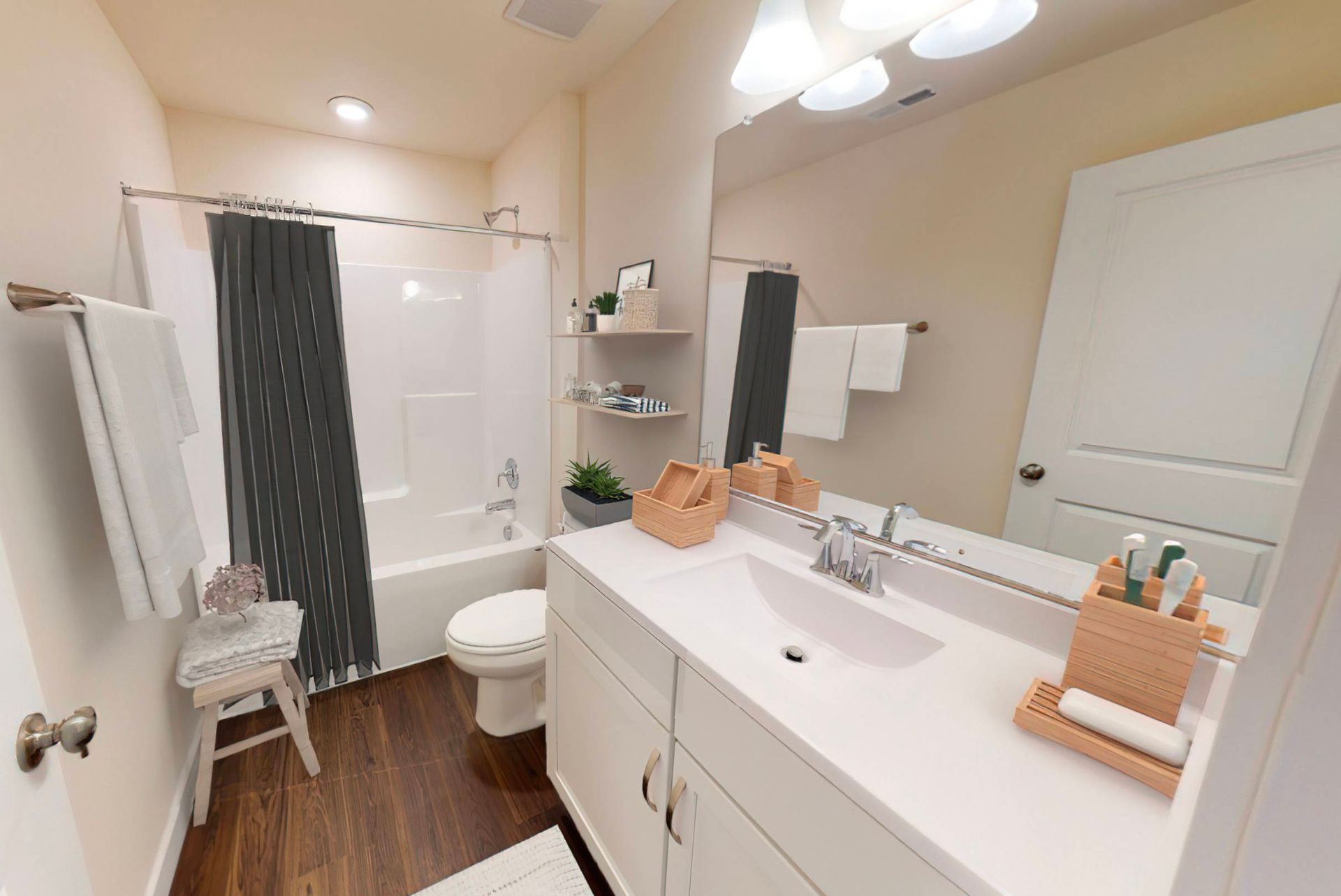 A bathroom with a sink , toilet , shower and mirror.