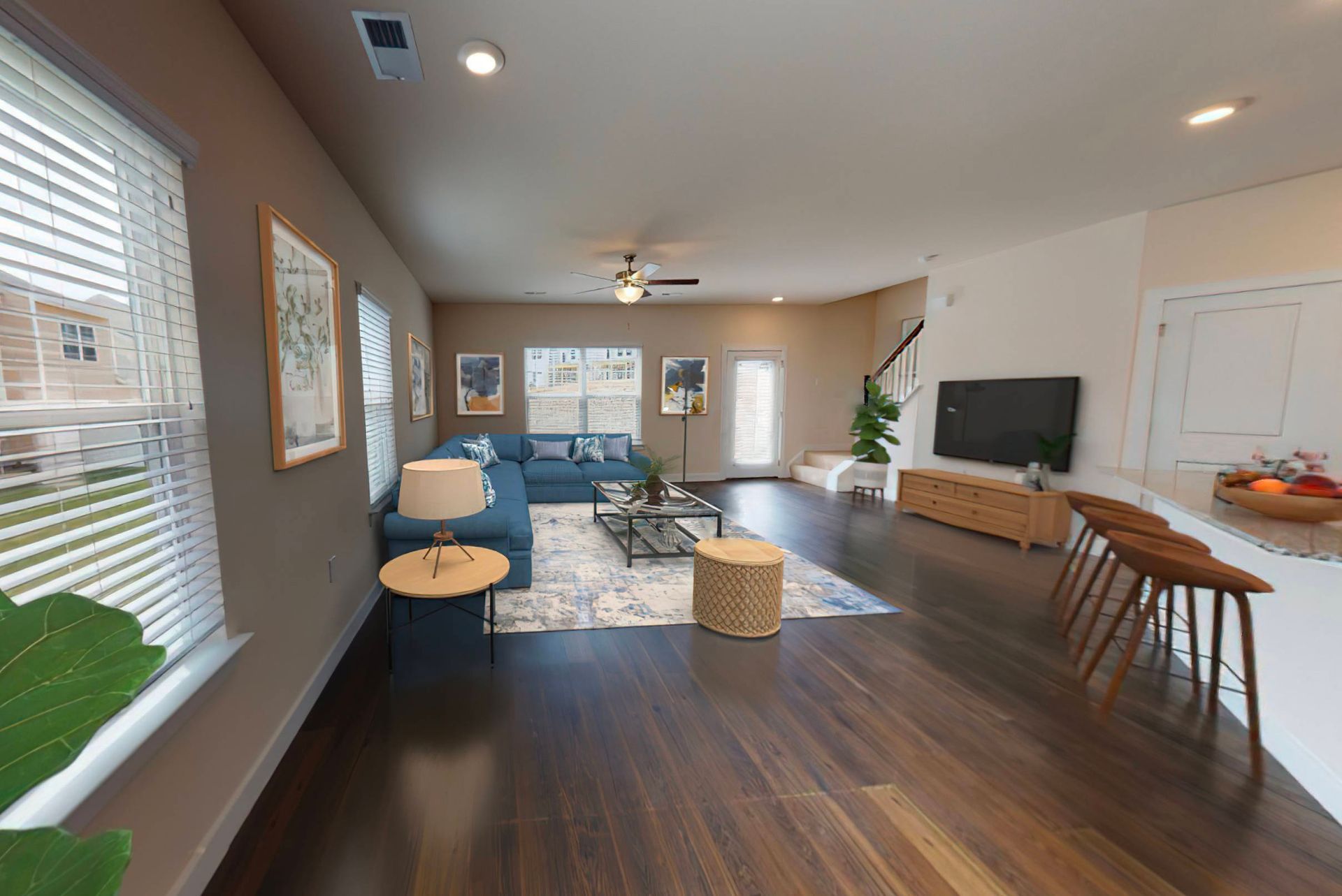 A living room with hardwood floors and a blue couch.