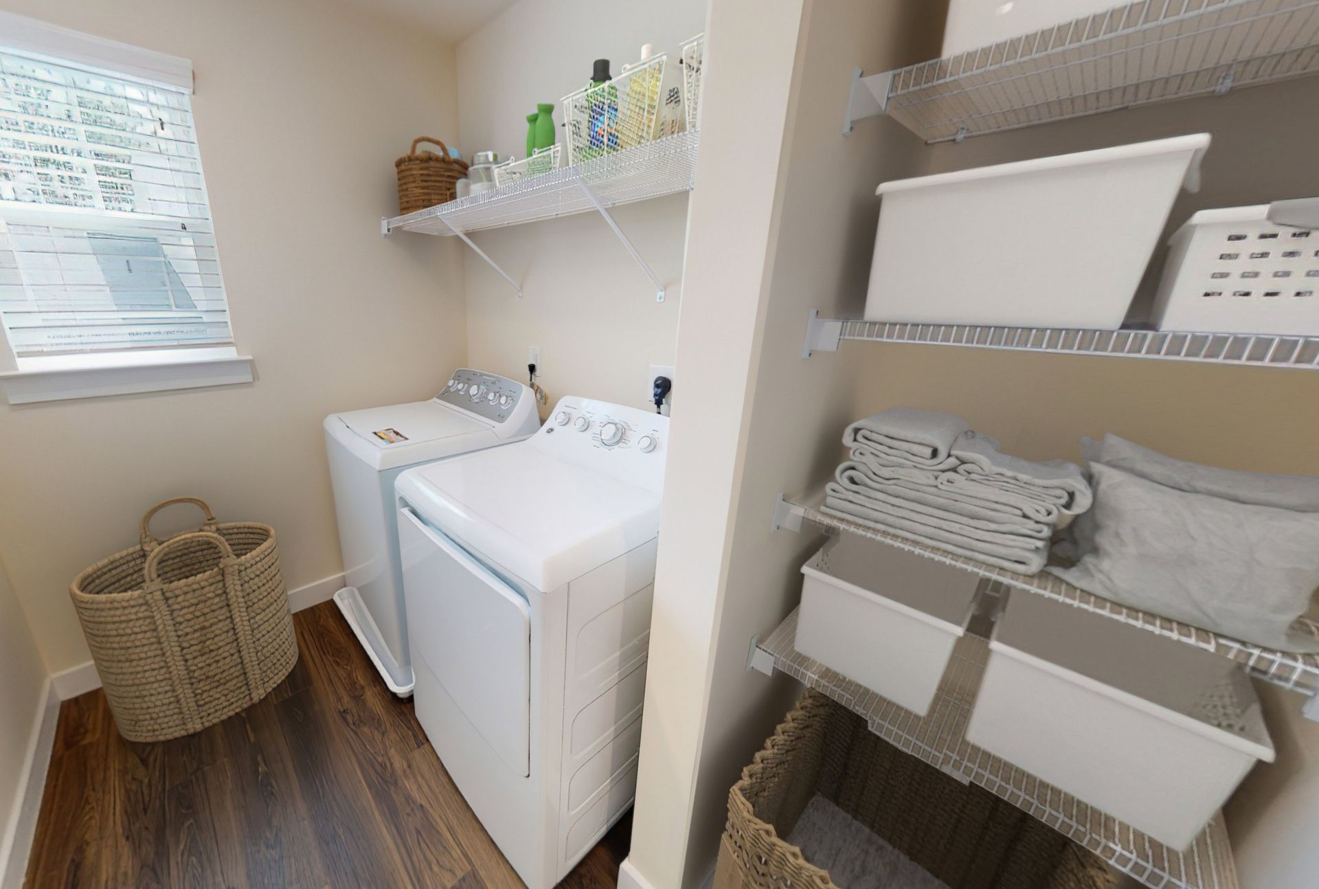 A laundry room with a washer and dryer and baskets.