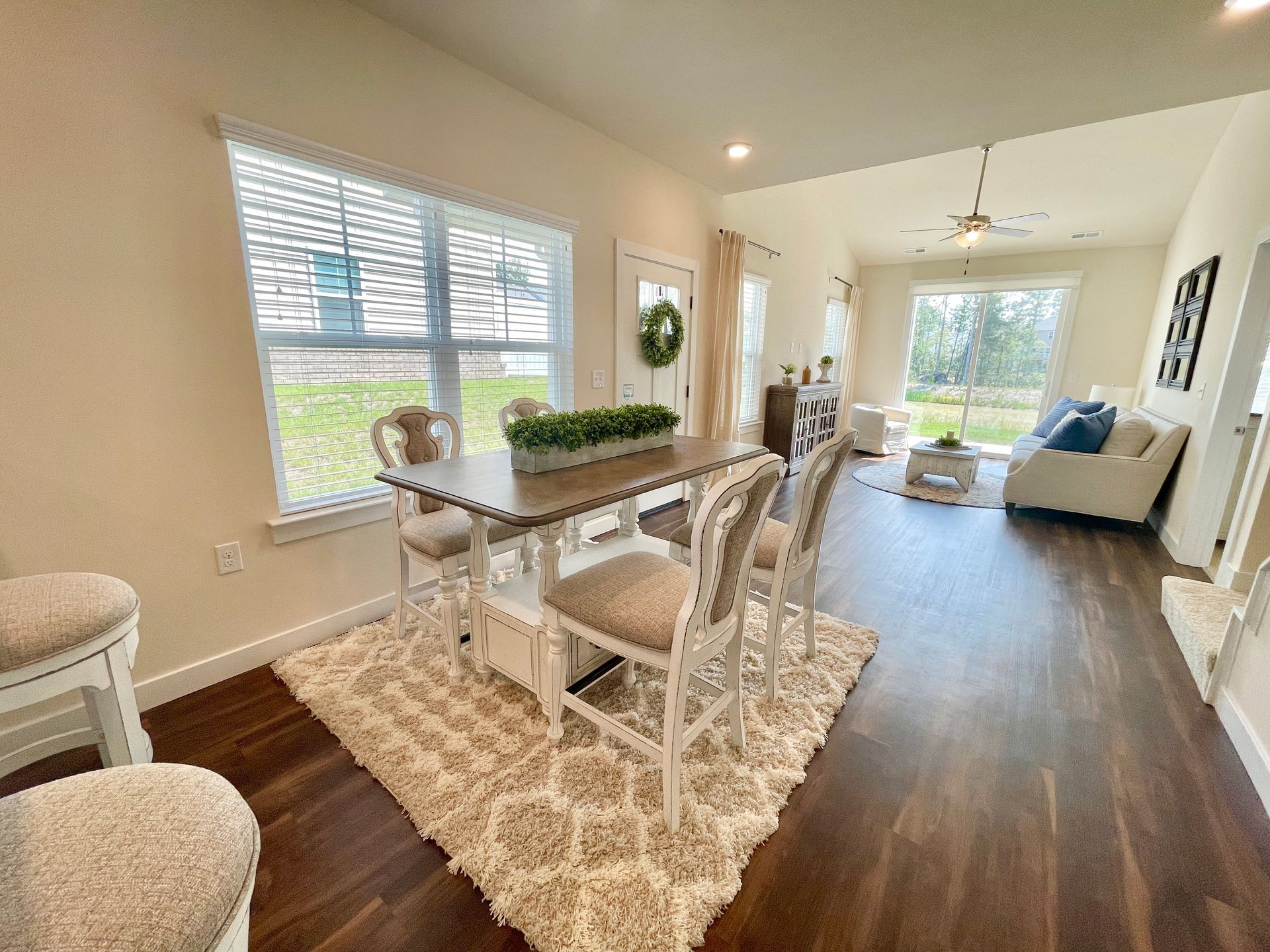 A dining room with a table and chairs and a rug.