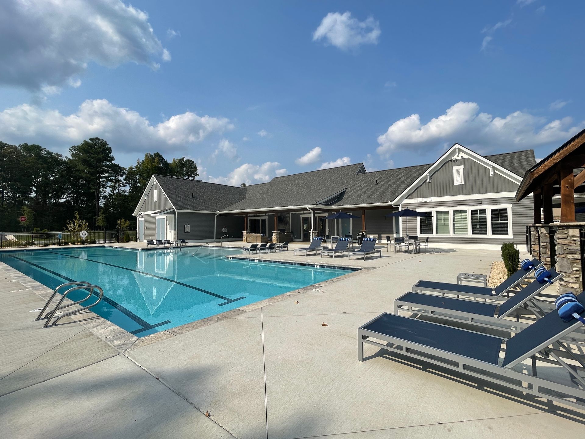 A large swimming pool with a house in the background