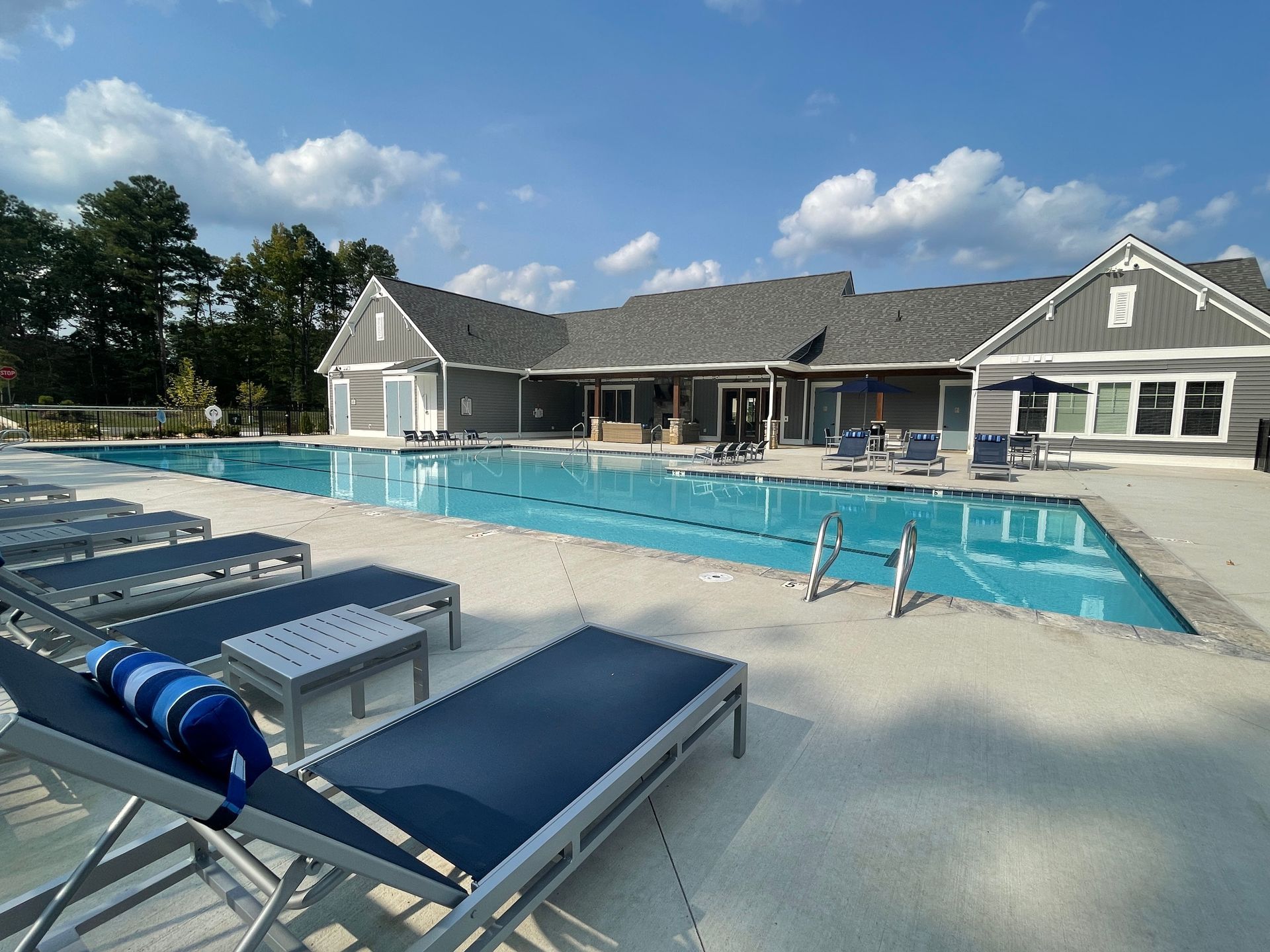 A large swimming pool with a house in the background