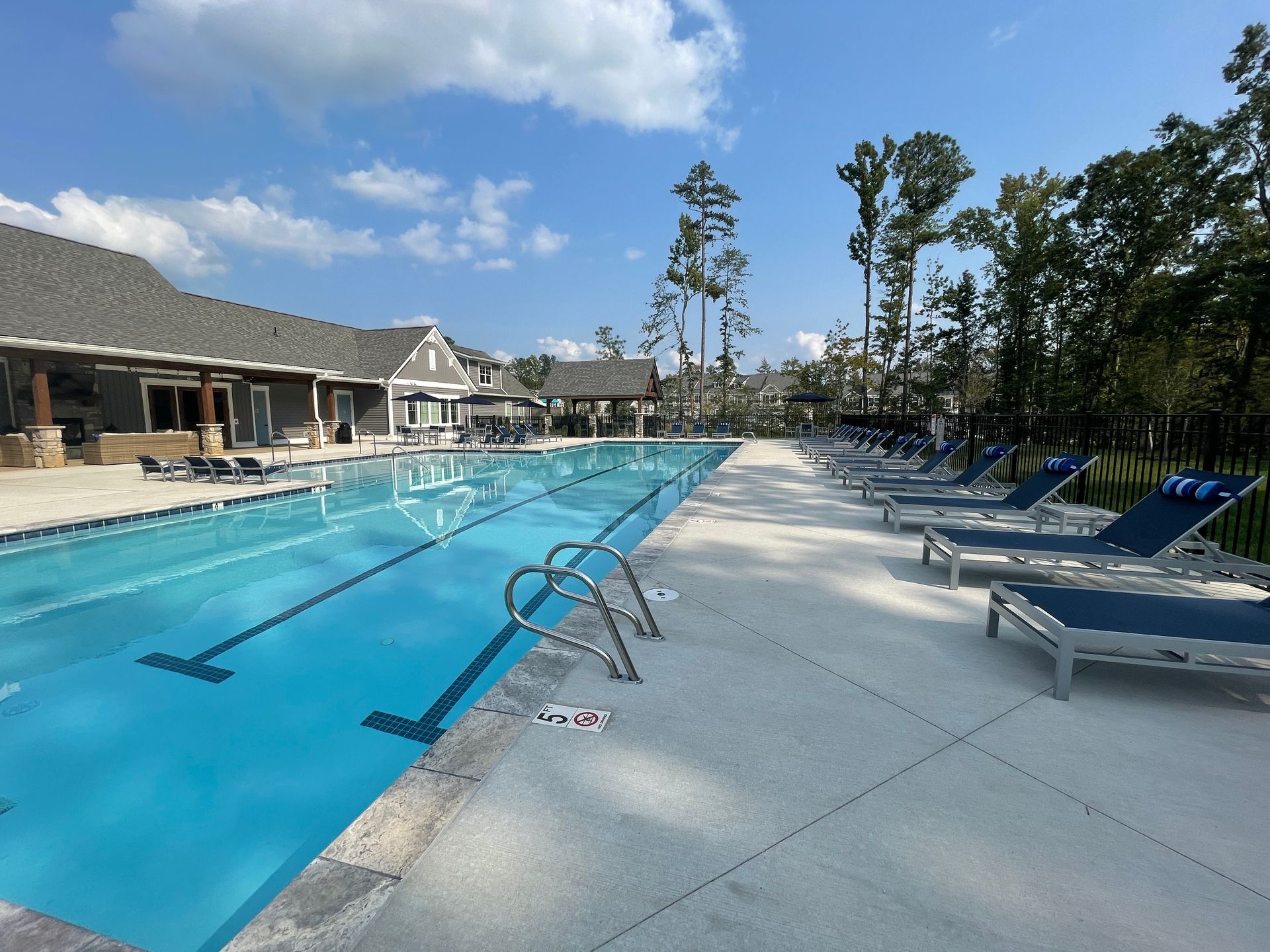 A large swimming pool with a lot of chairs around it