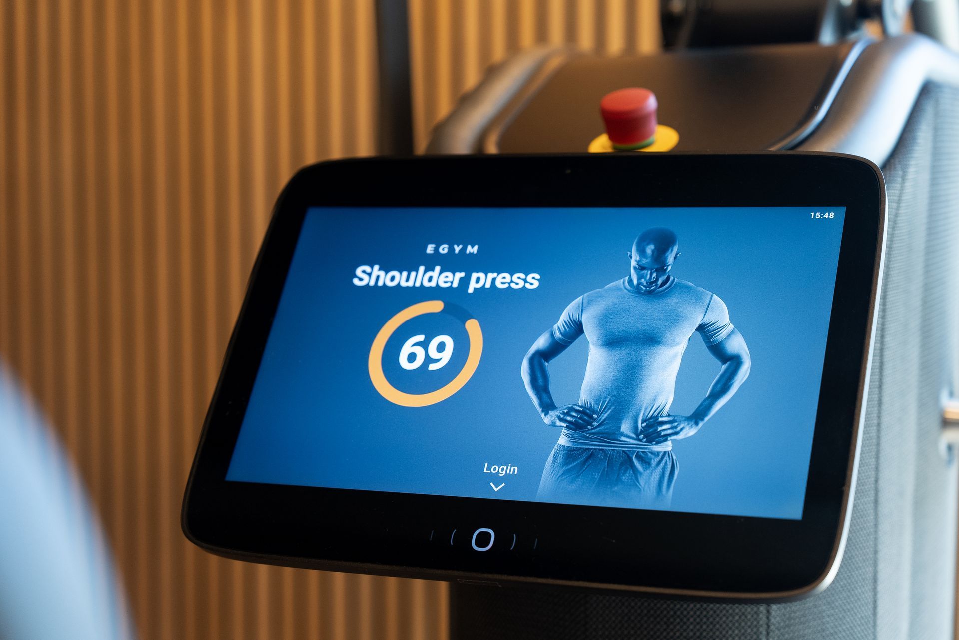 Een man doet schouderpersoefeningen op een machine.