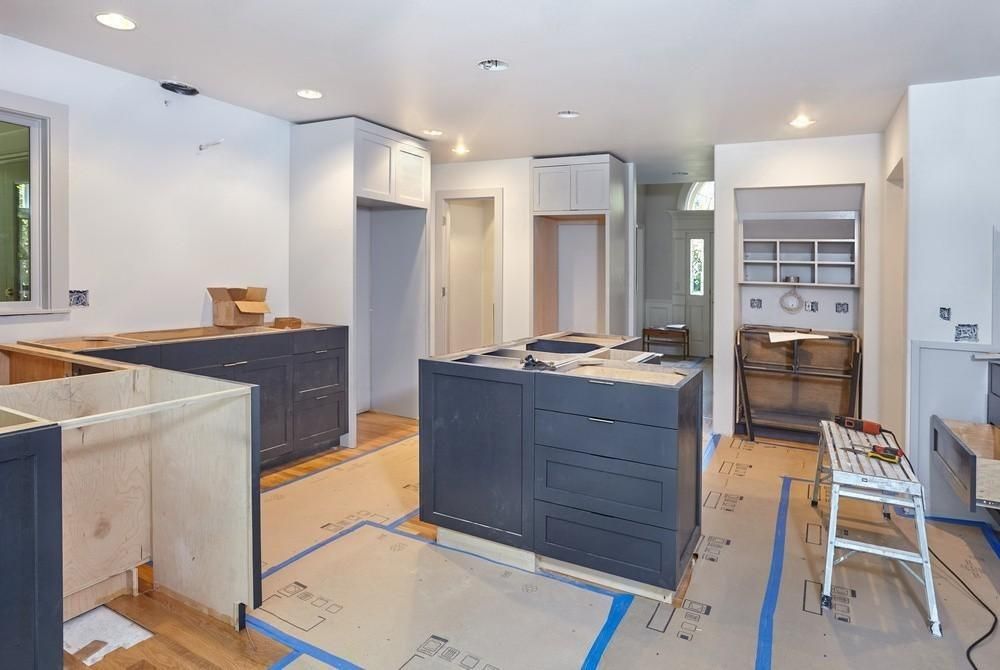 a kitchen under construction with a large island in the middle of the room .