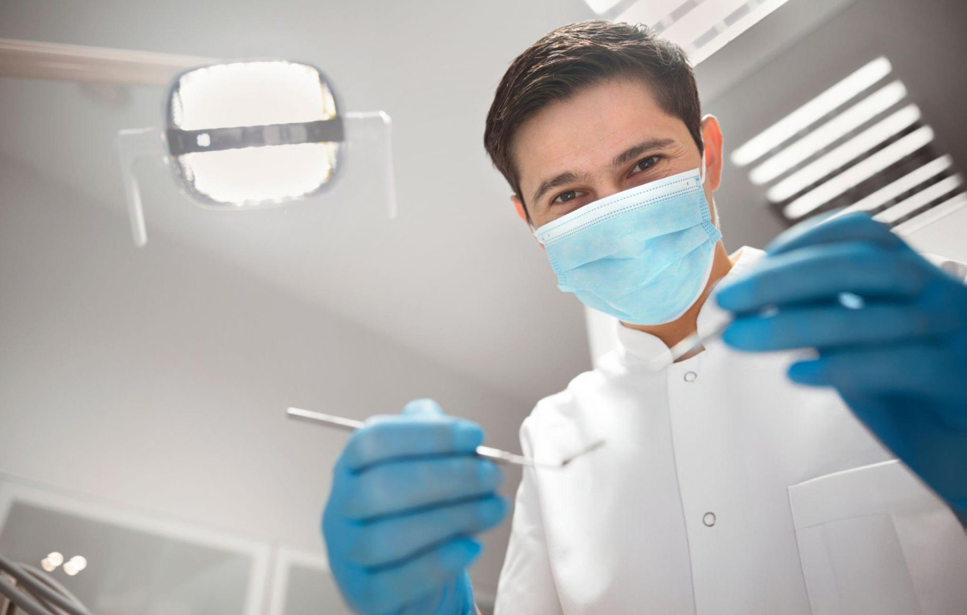 Dentist holding dental equipment in clinic