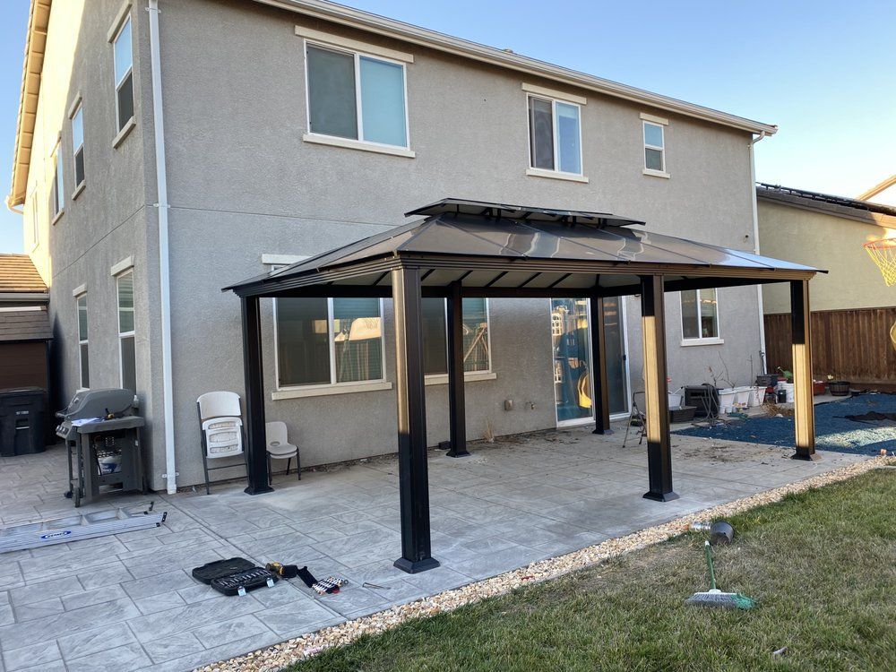 There is a gazebo in the backyard of a house.
