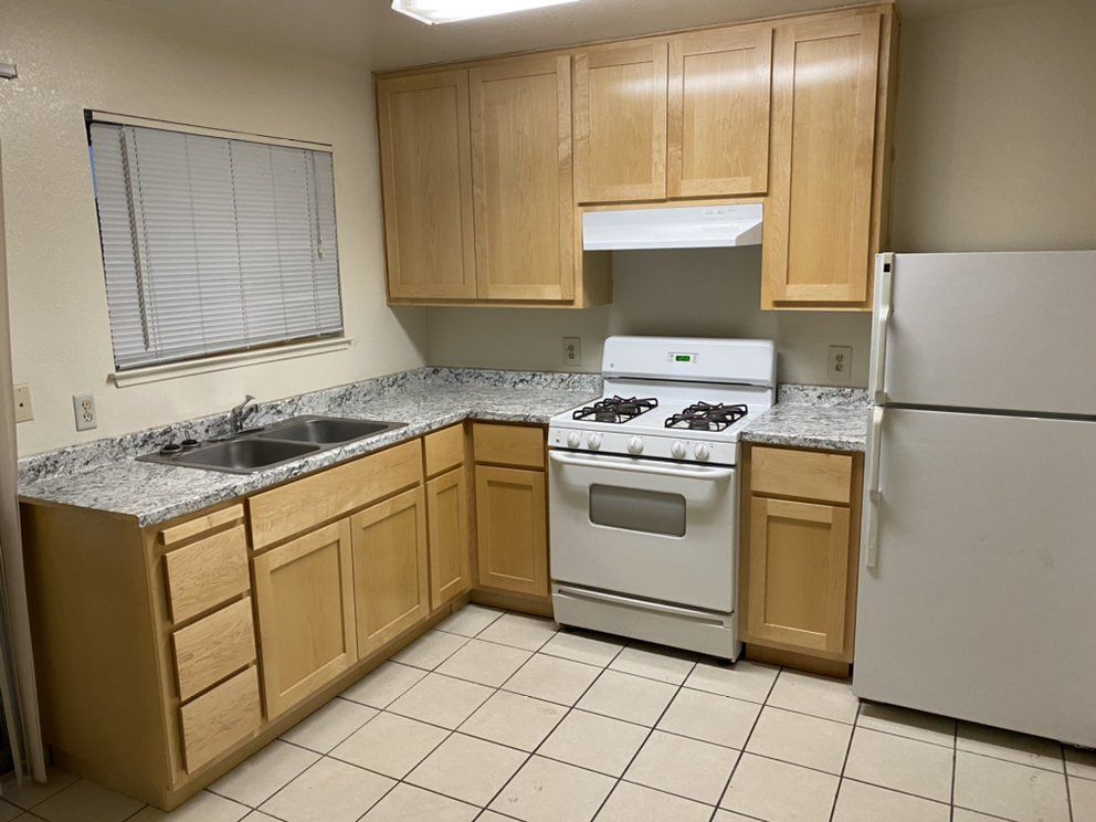 A kitchen with a stove , sink , and refrigerator