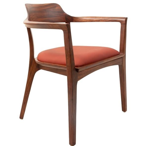 Silla de madera con cojín rojo.