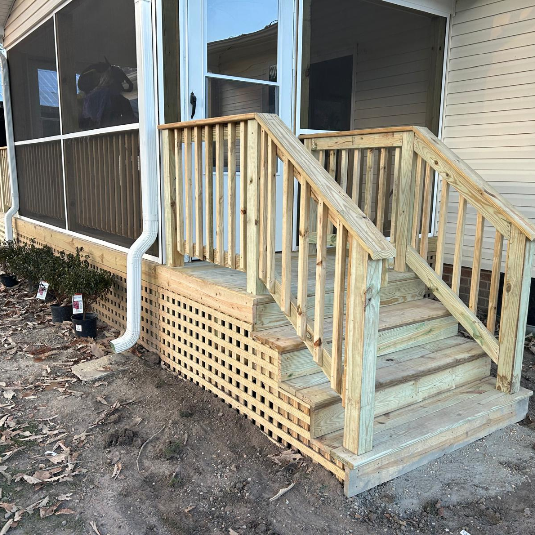 Wooden porch with stairs and railing, latticework base.