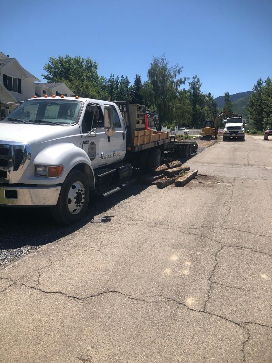 A white tow truck is parked on the side of the road.