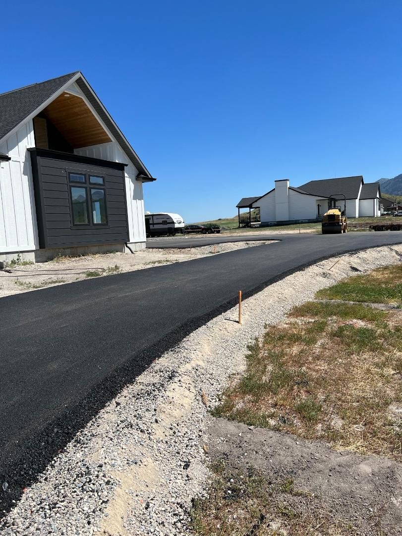 A house is being built next to a road that is being paved.