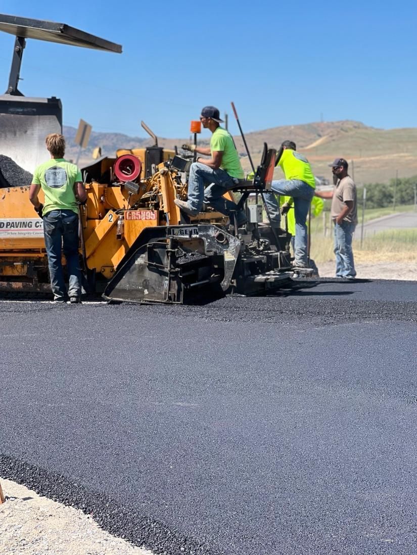 A group of construction workers are working on a road.