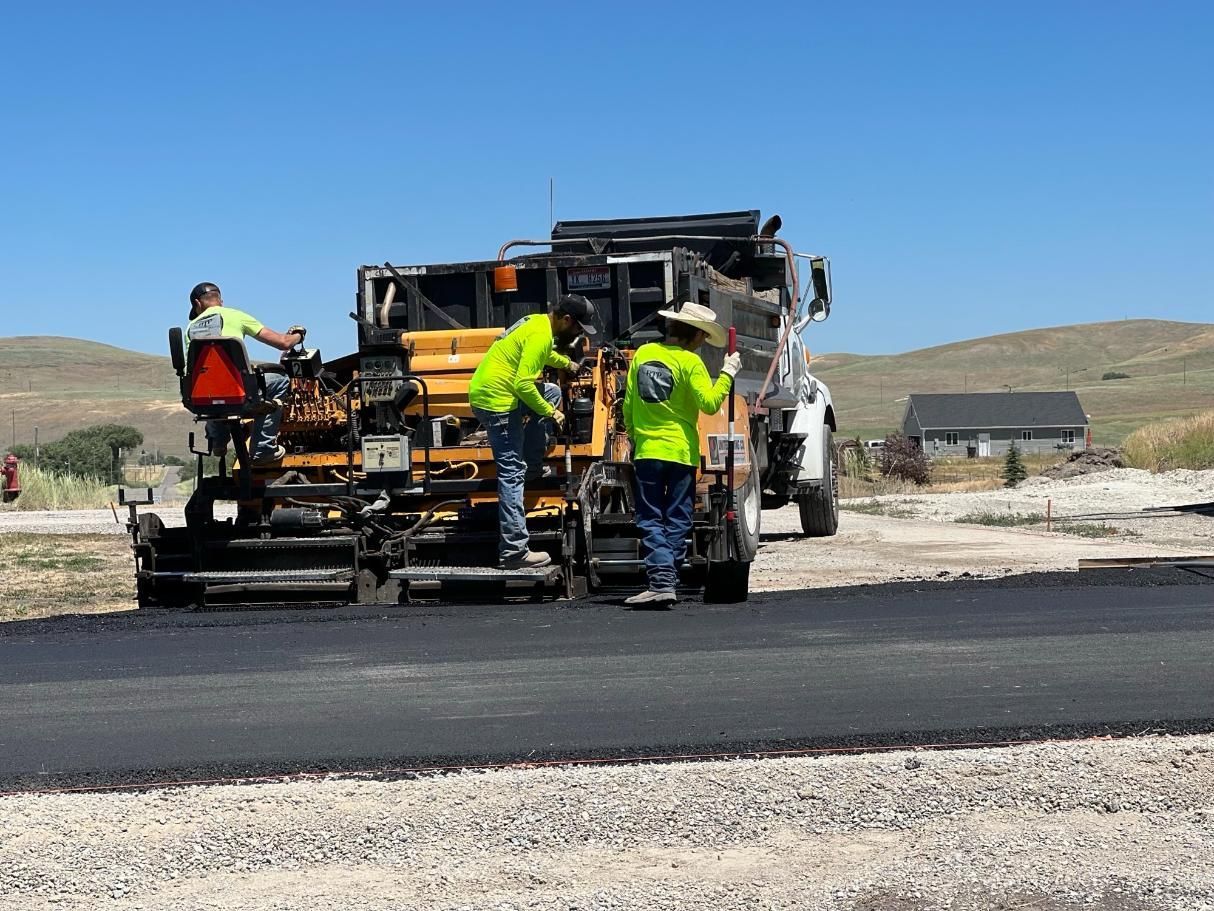 A group of construction workers are working on a road.