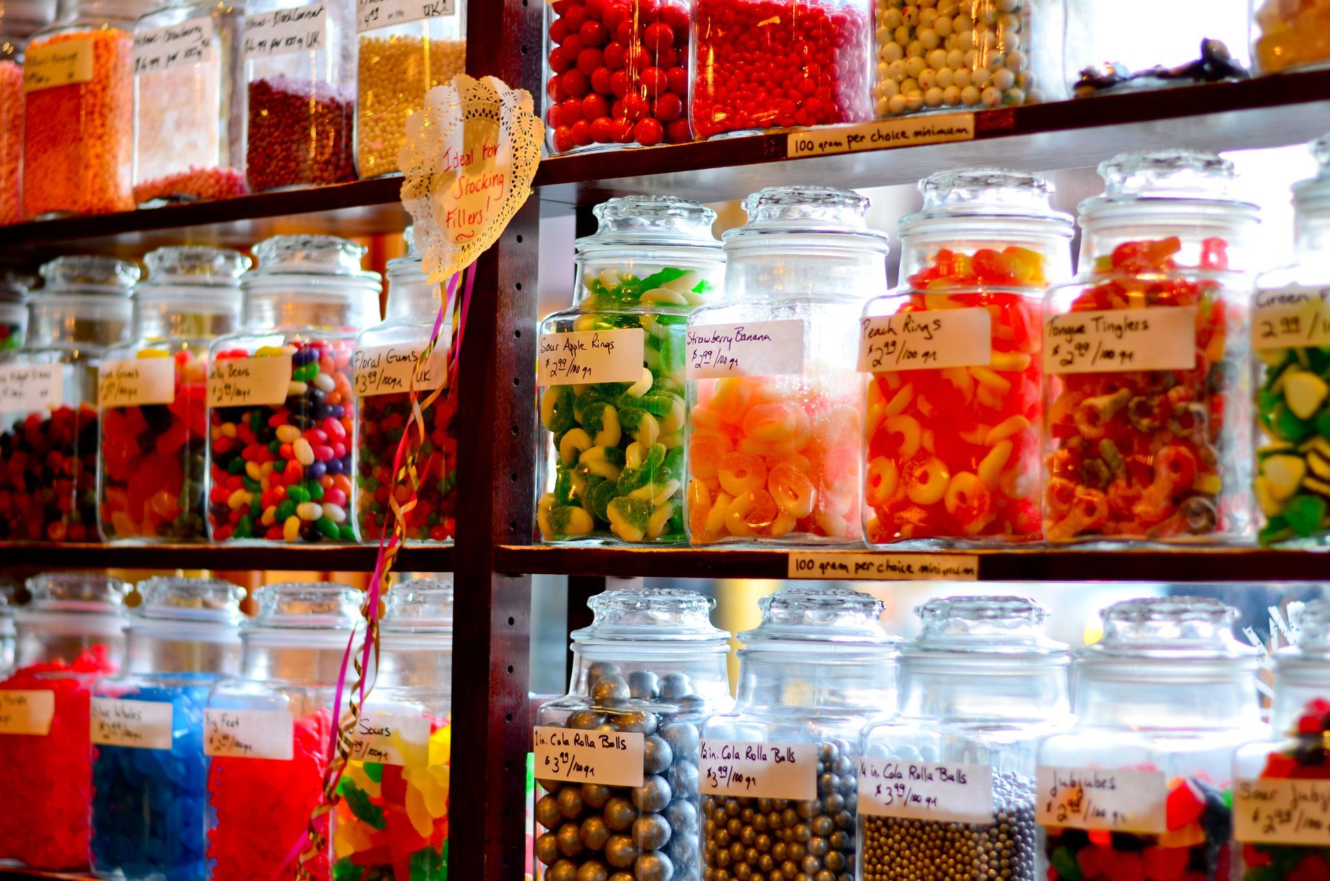 A shelf full of jars filled with different types of candy.