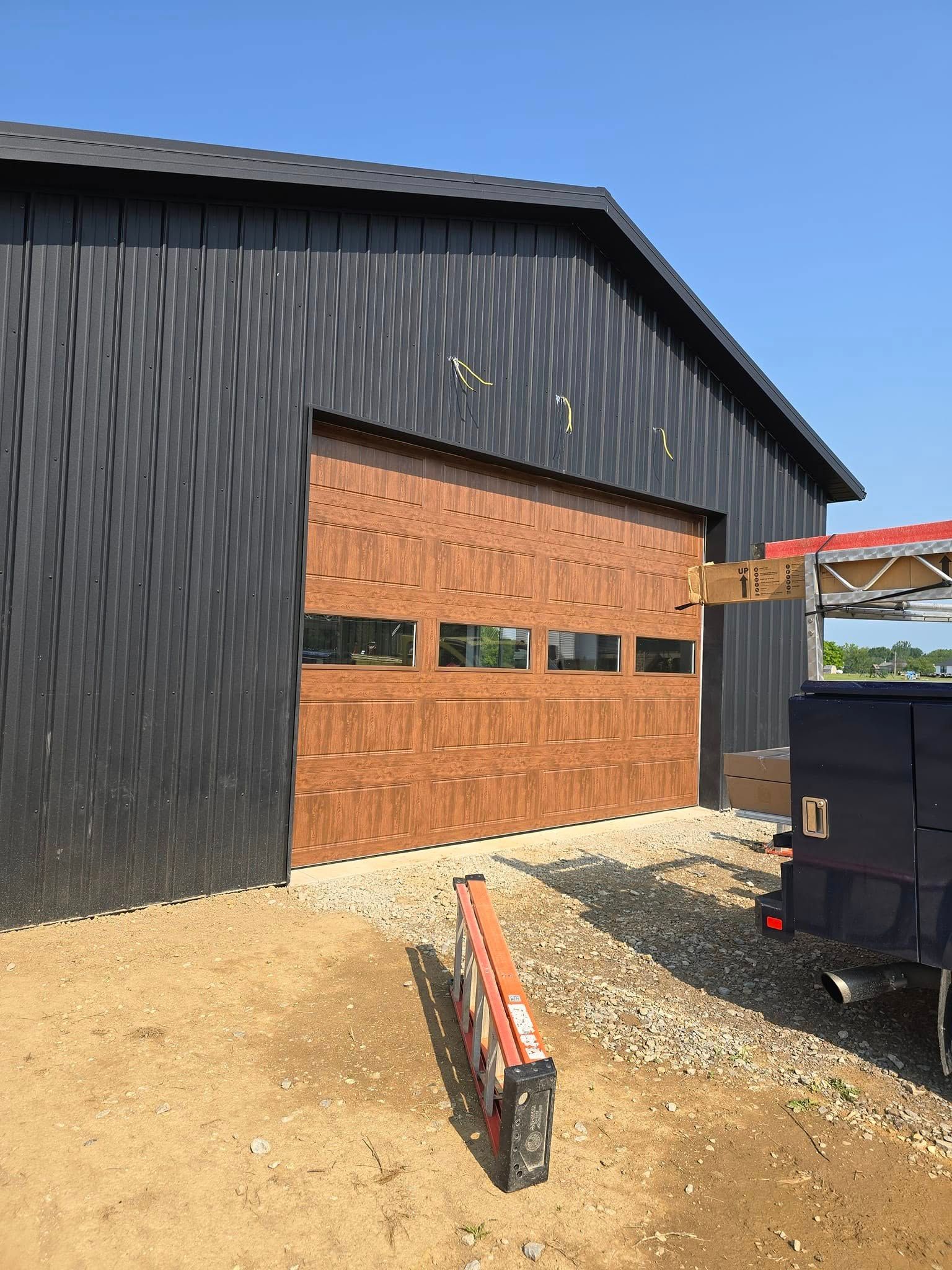 Brown garage door on a black building, construction site.