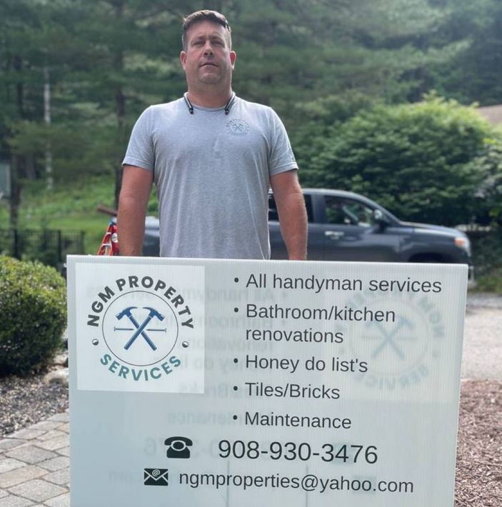 A man standing next to a sign that says mgm property services