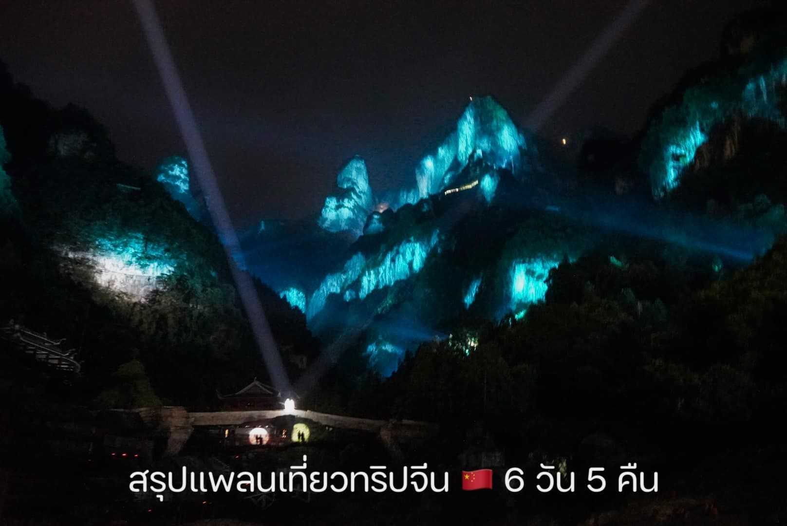 A mountain is lit up with blue lights at night.