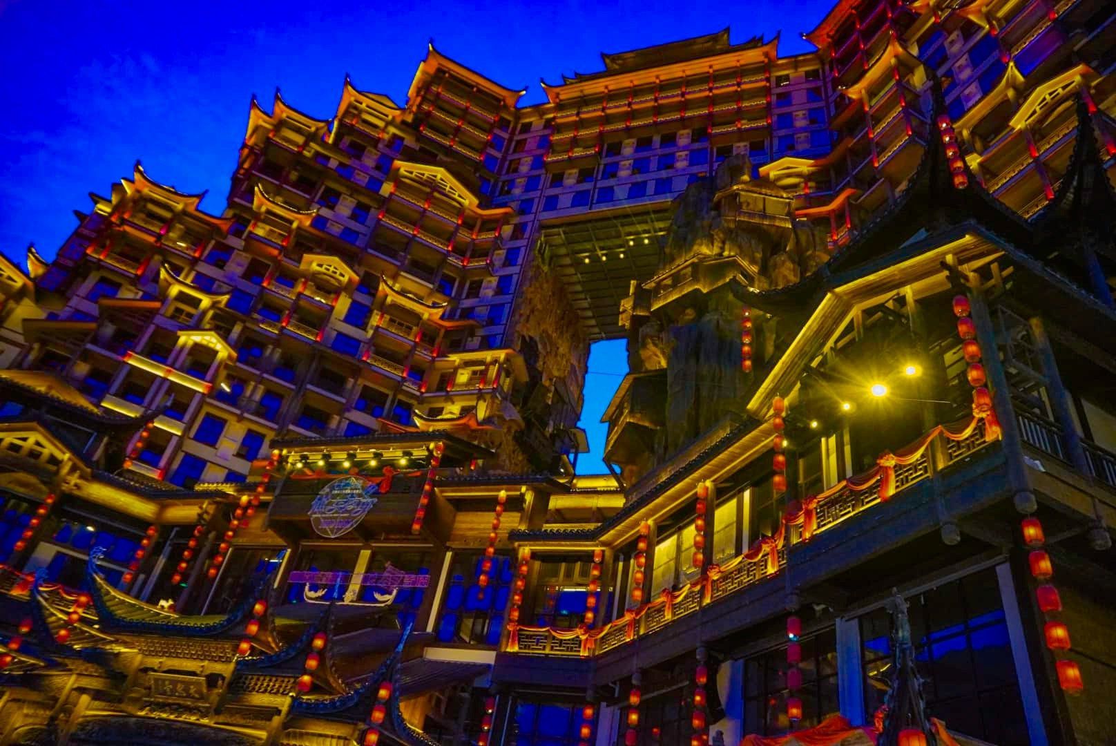 A large building with a lot of windows is lit up at night.