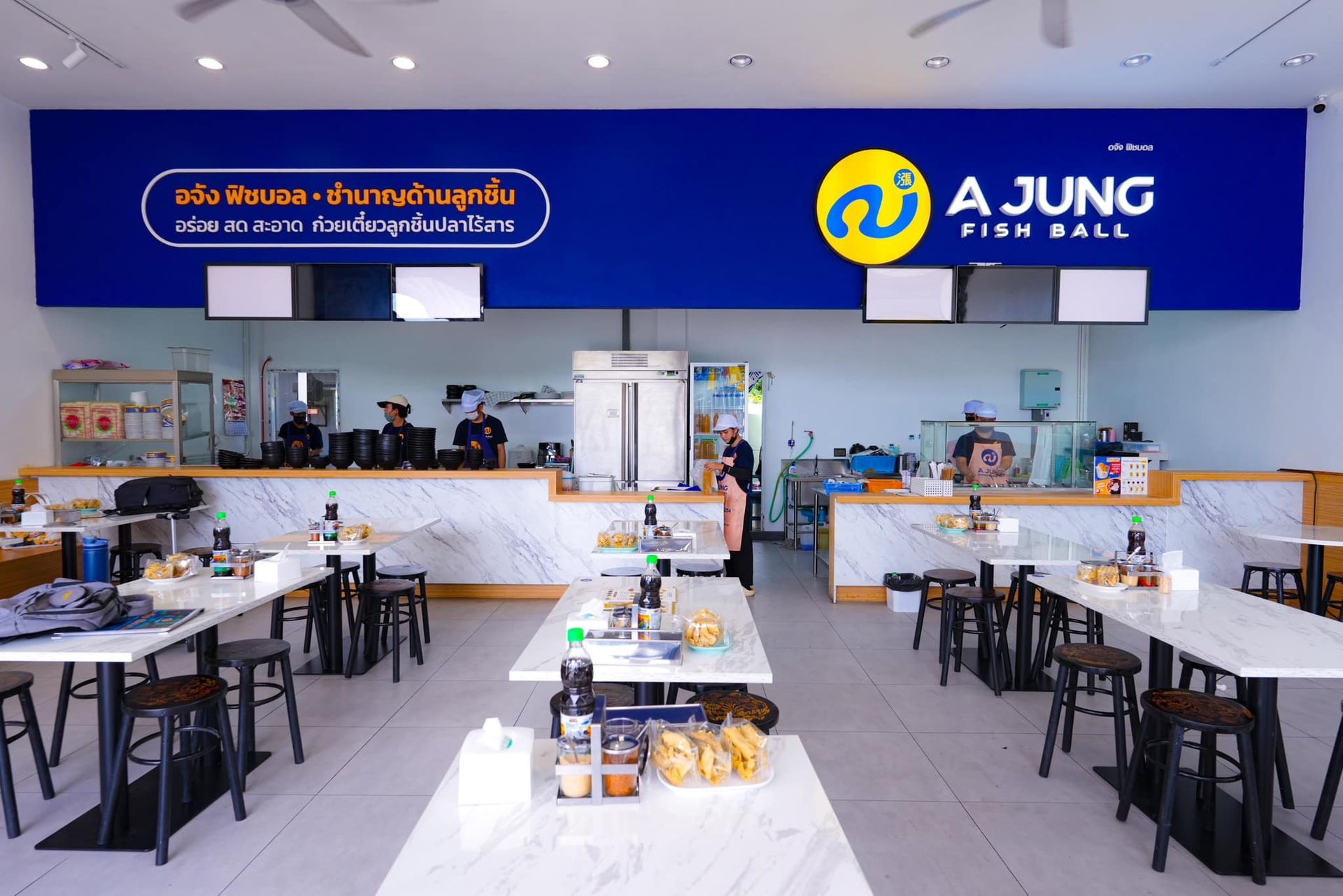 A restaurant with tables and chairs and a sign that says