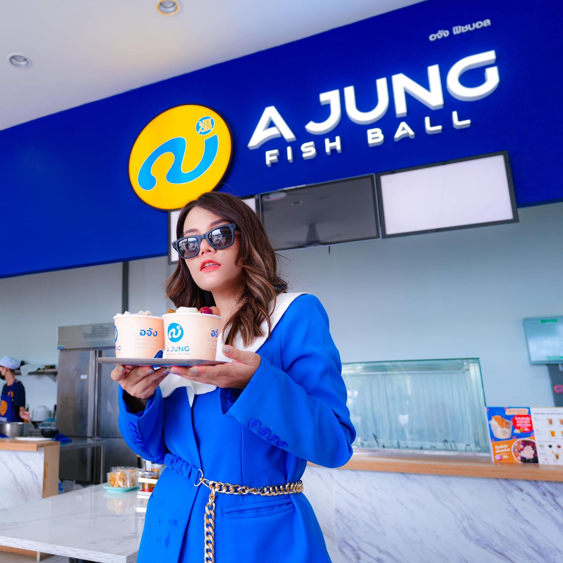 A woman is standing in front of a sign that says