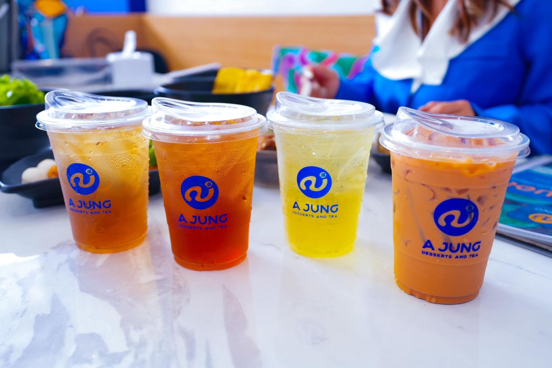 Four cups of drinks are sitting on a table.