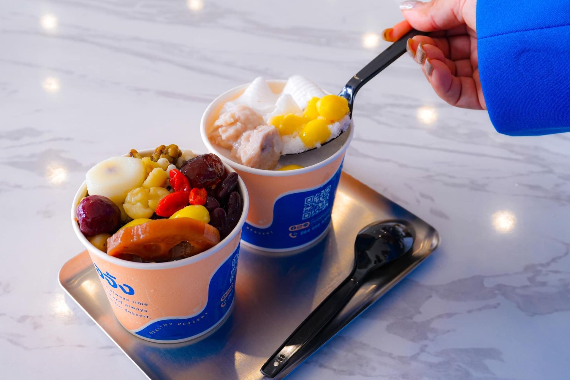 A person is scooping ice cream out of a cup with a spoon.